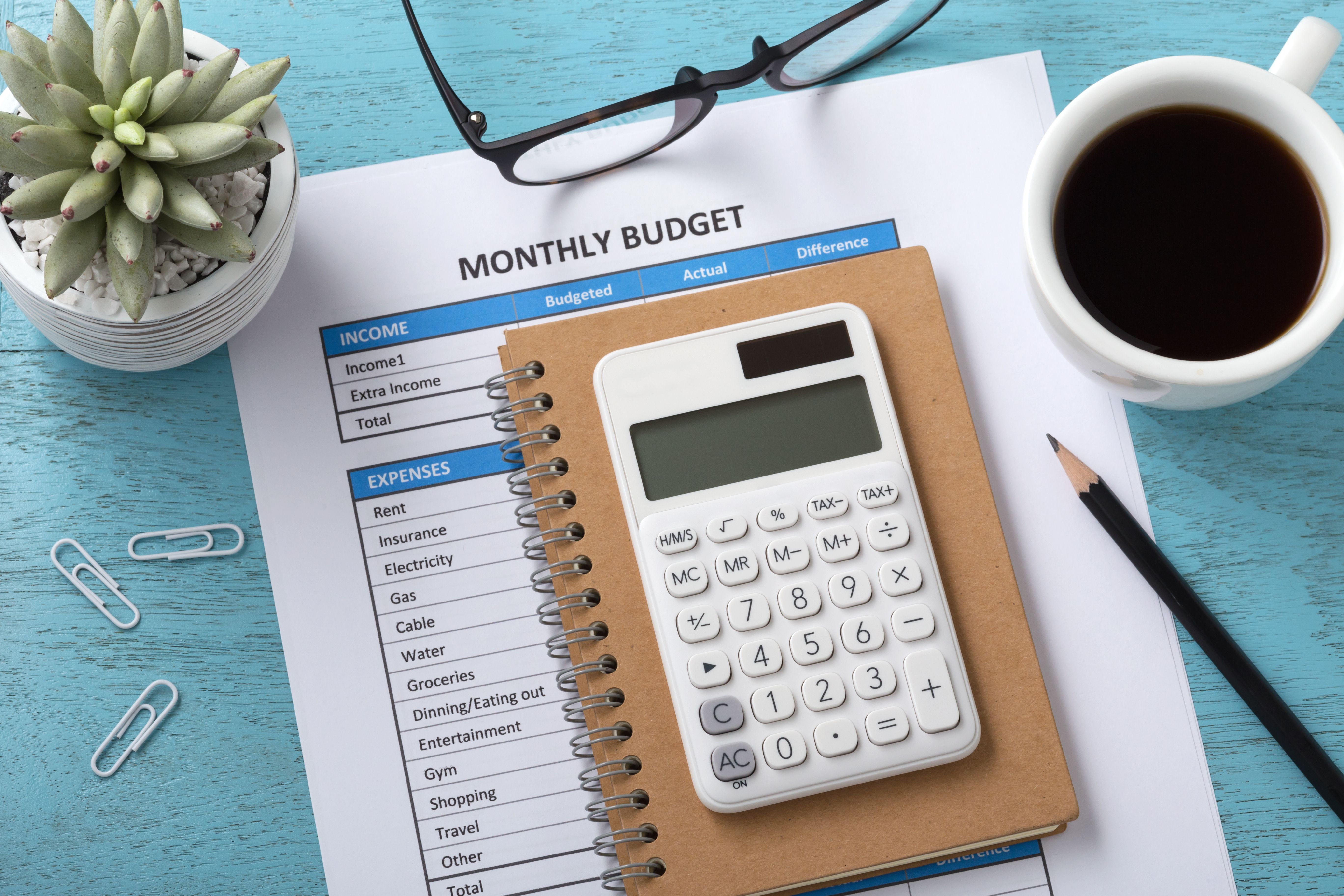 Monthly budget with white calculator on blue table