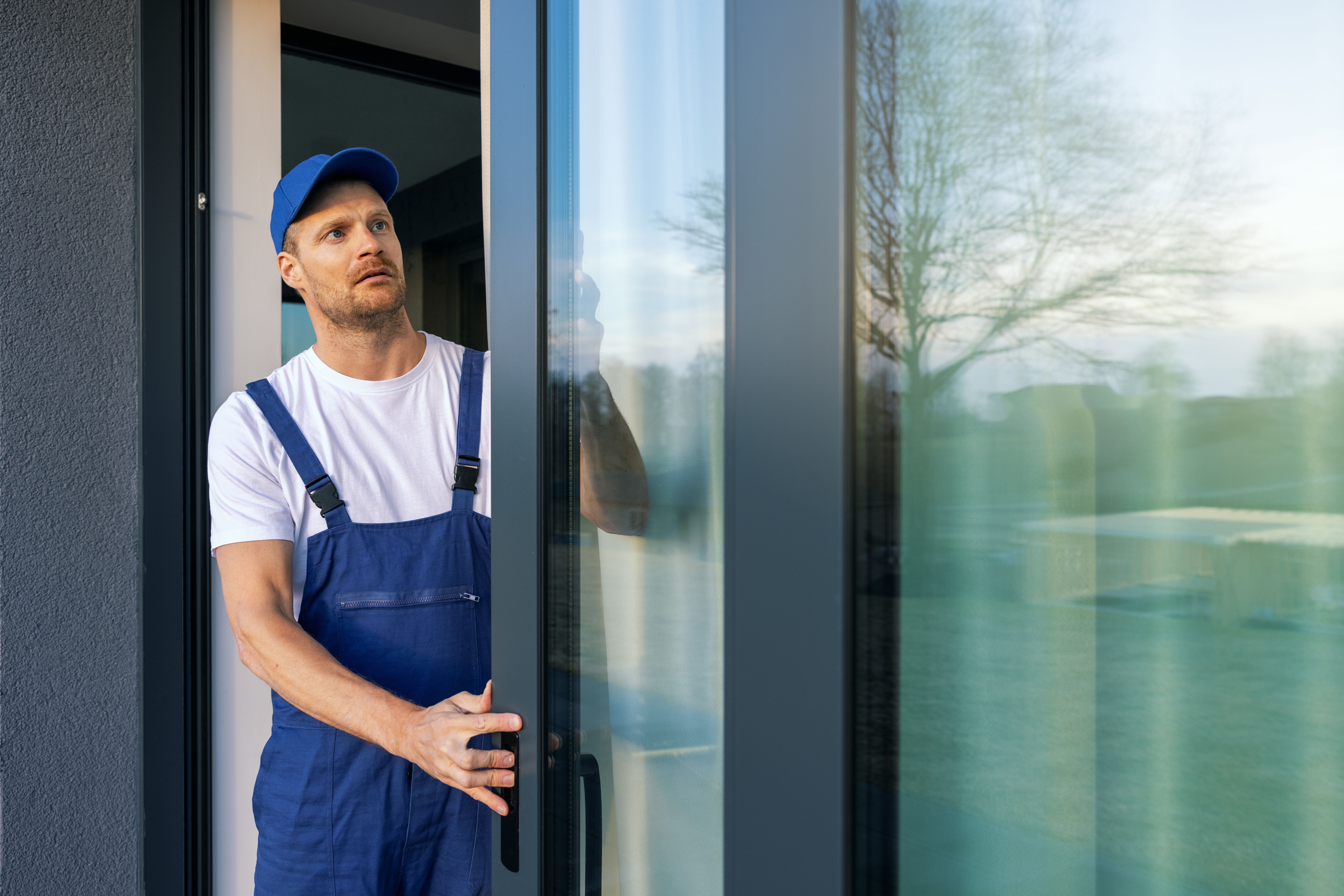 man installing aluminium frame sliding terrace doors