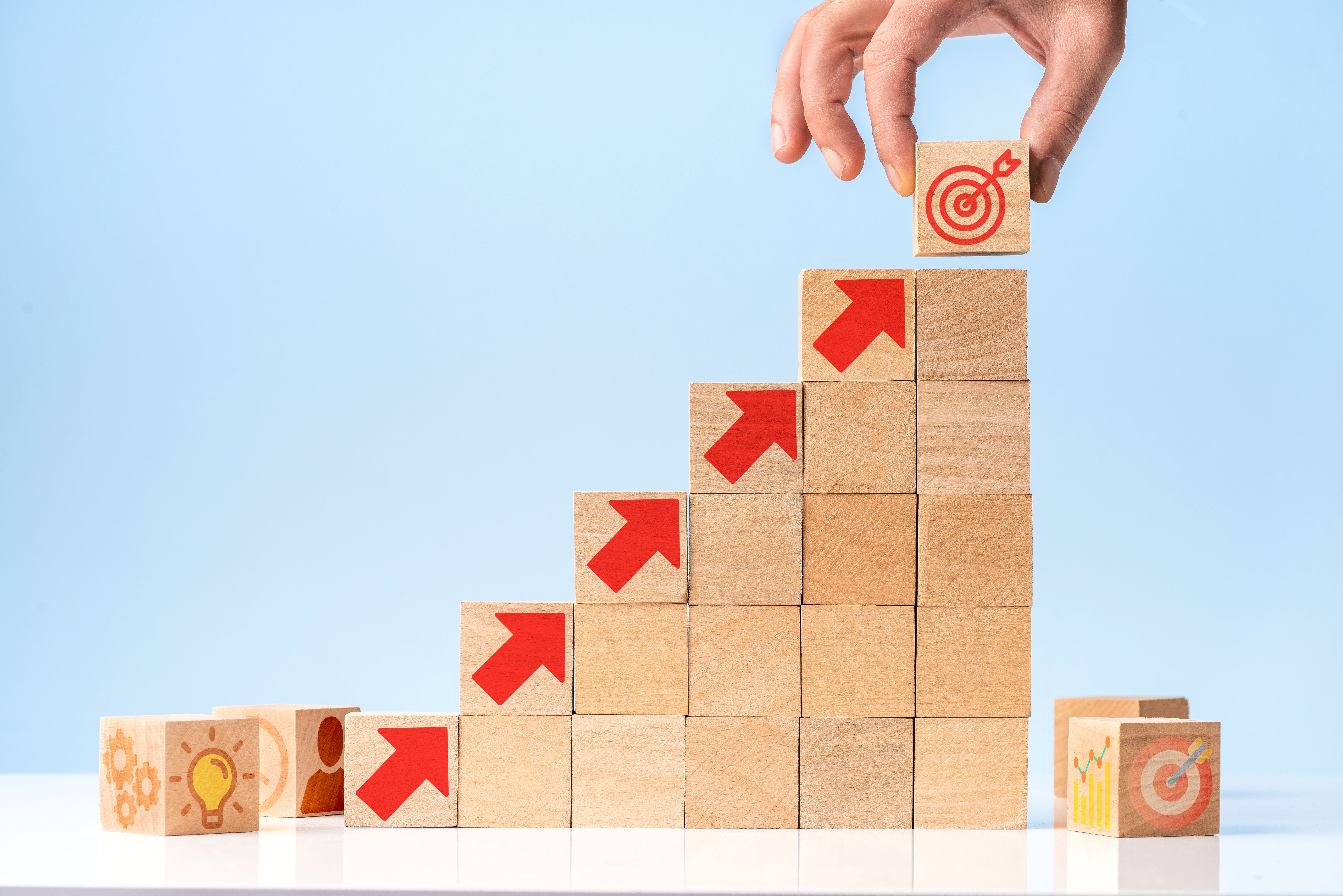 Businessman putting dart wooden cube with hand. Business success concept.
