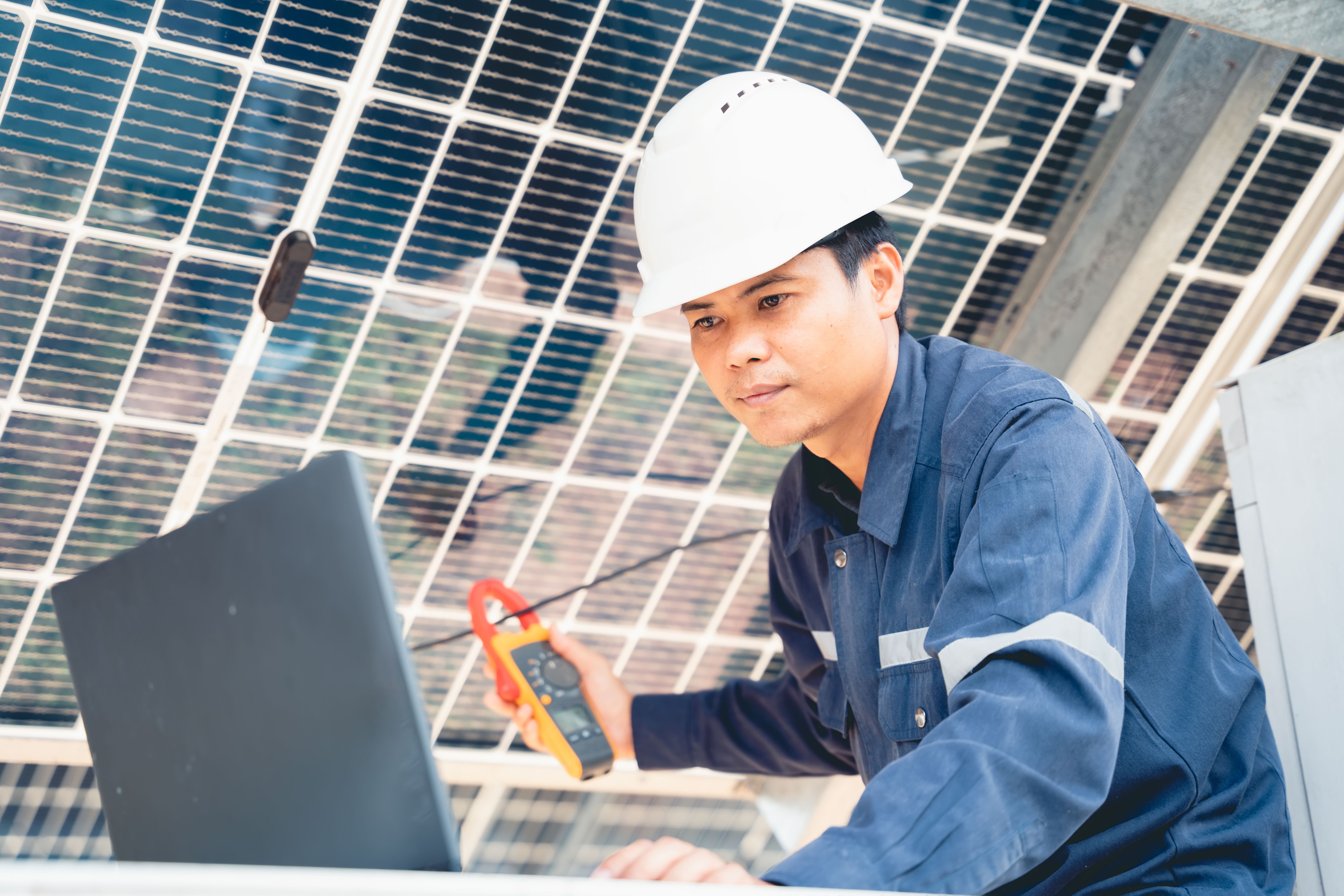 CAN Academy solar technician training with laptop and multimeter for field measurement