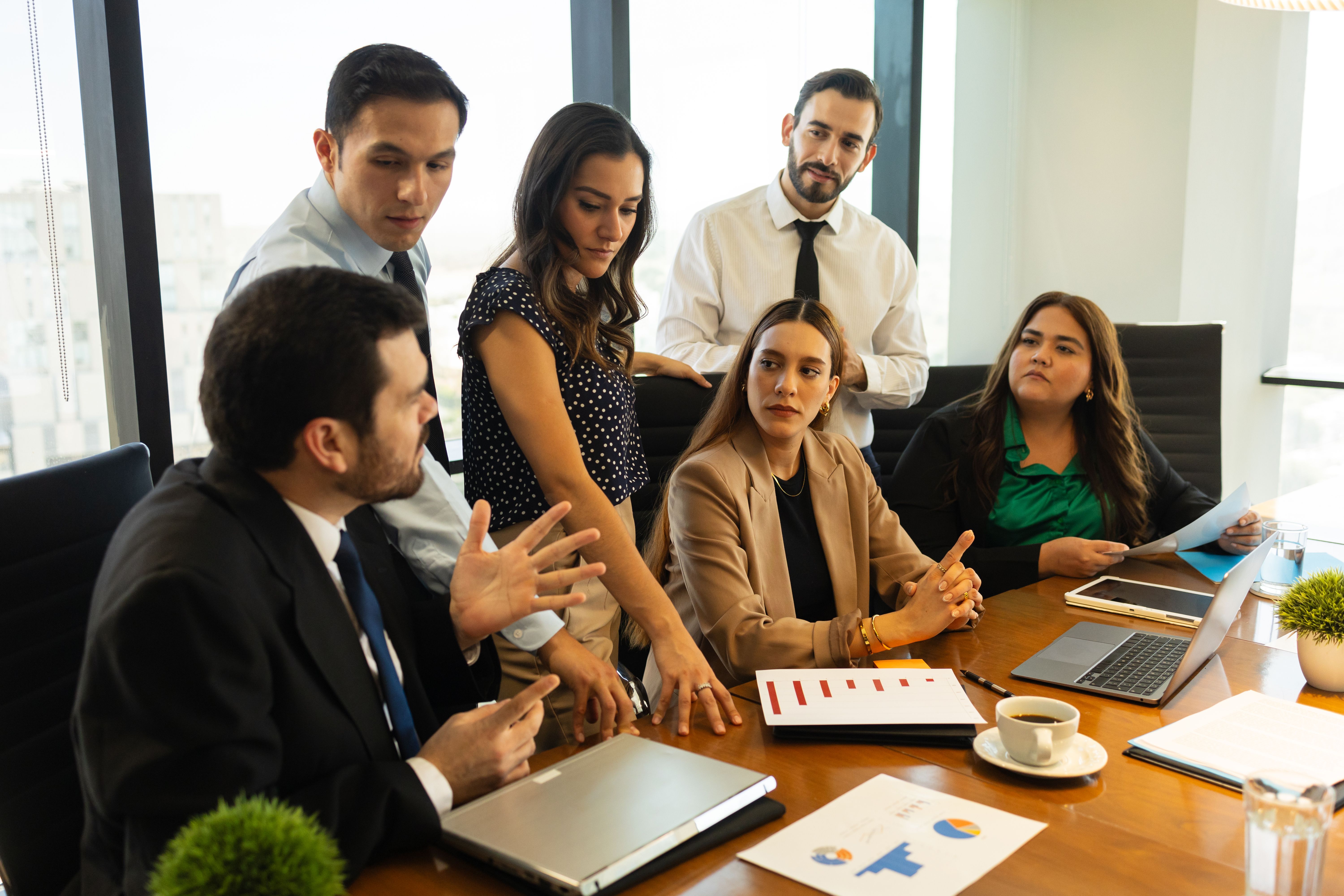 Group of businesspeople having a discussion in a meeting room and looking serious