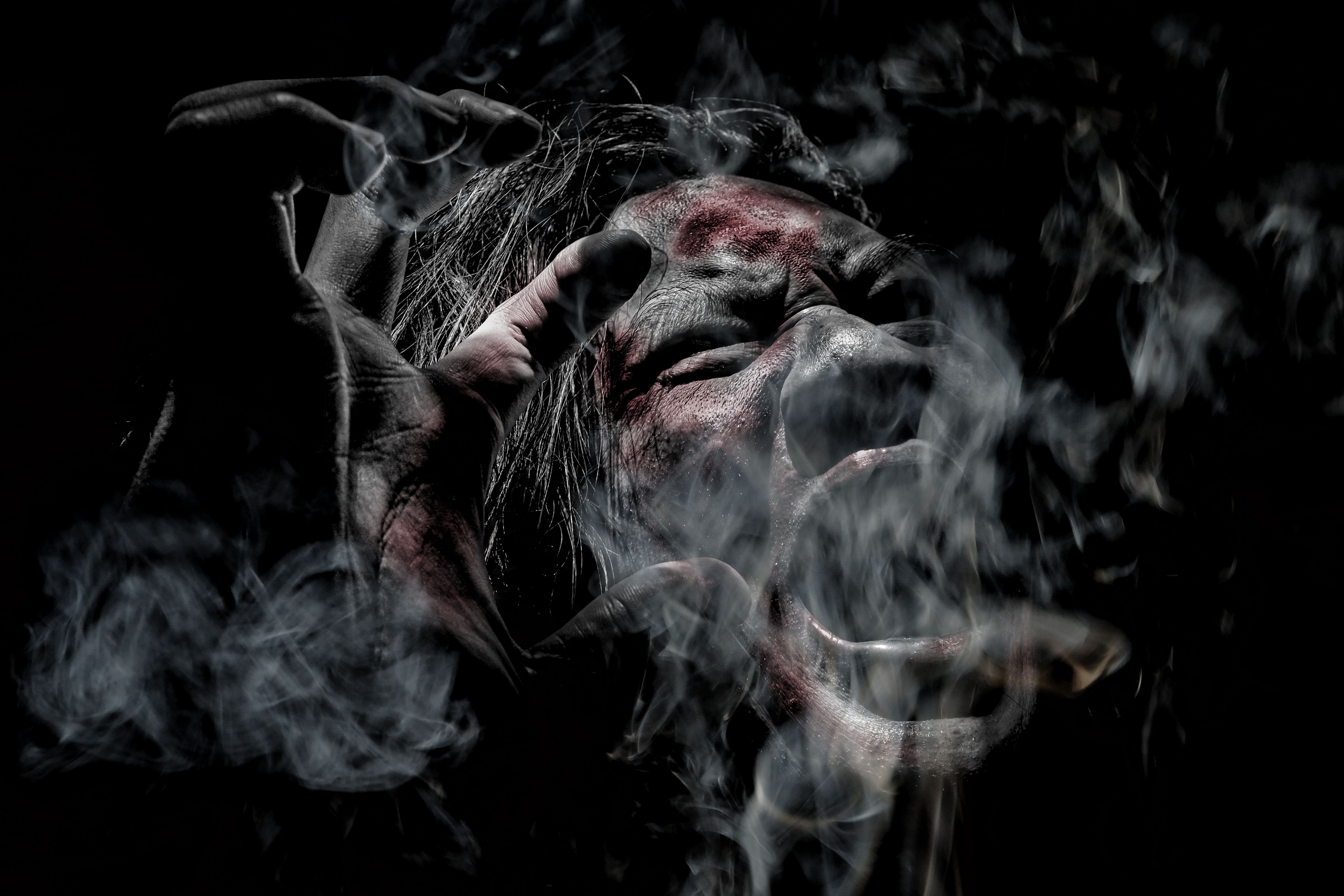 Terrifying Screaming Face Surrounded by Smoke in Dark Horror Scene