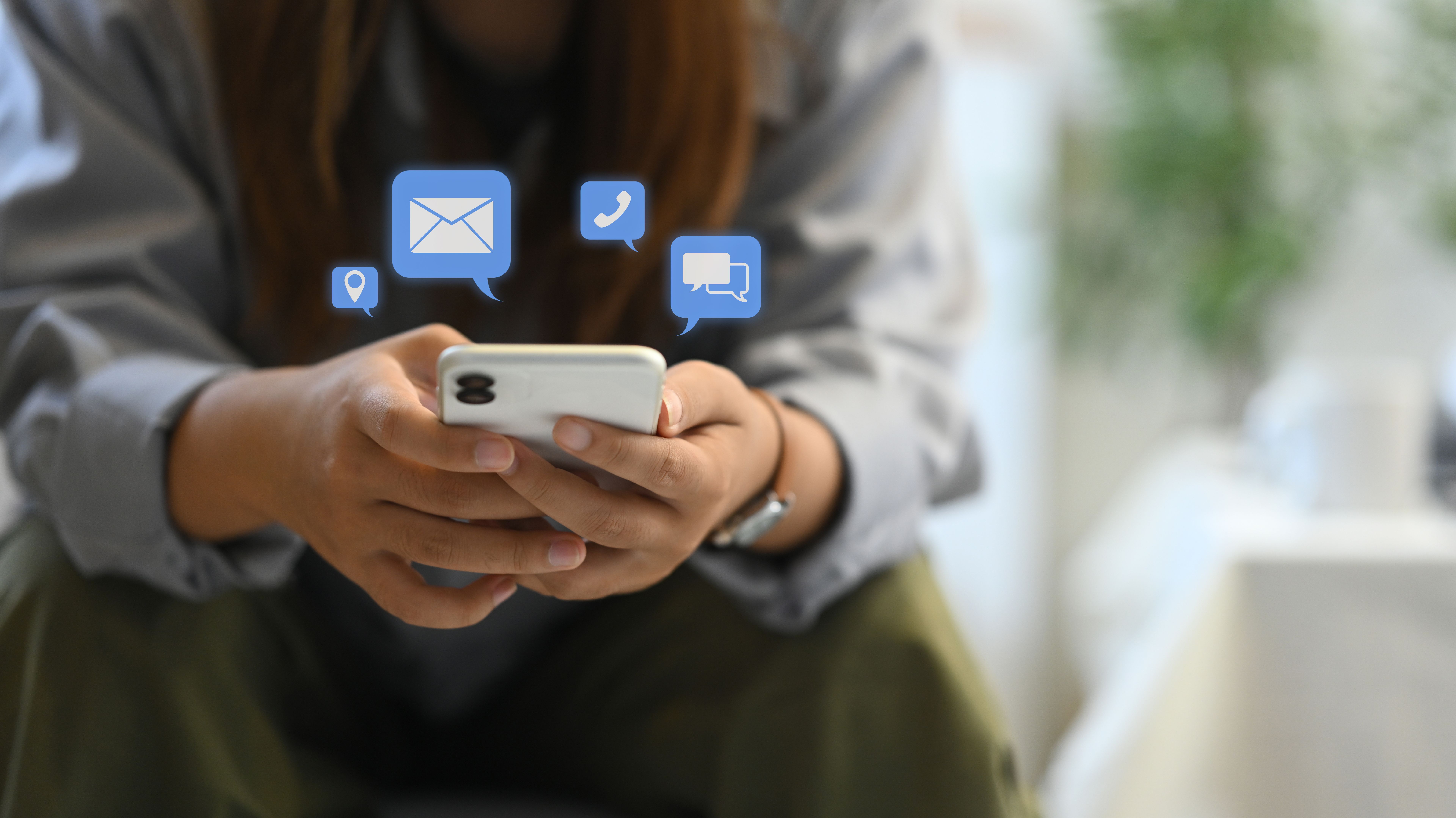 Female hands using smartphone with notification icons. Communication and technology concept