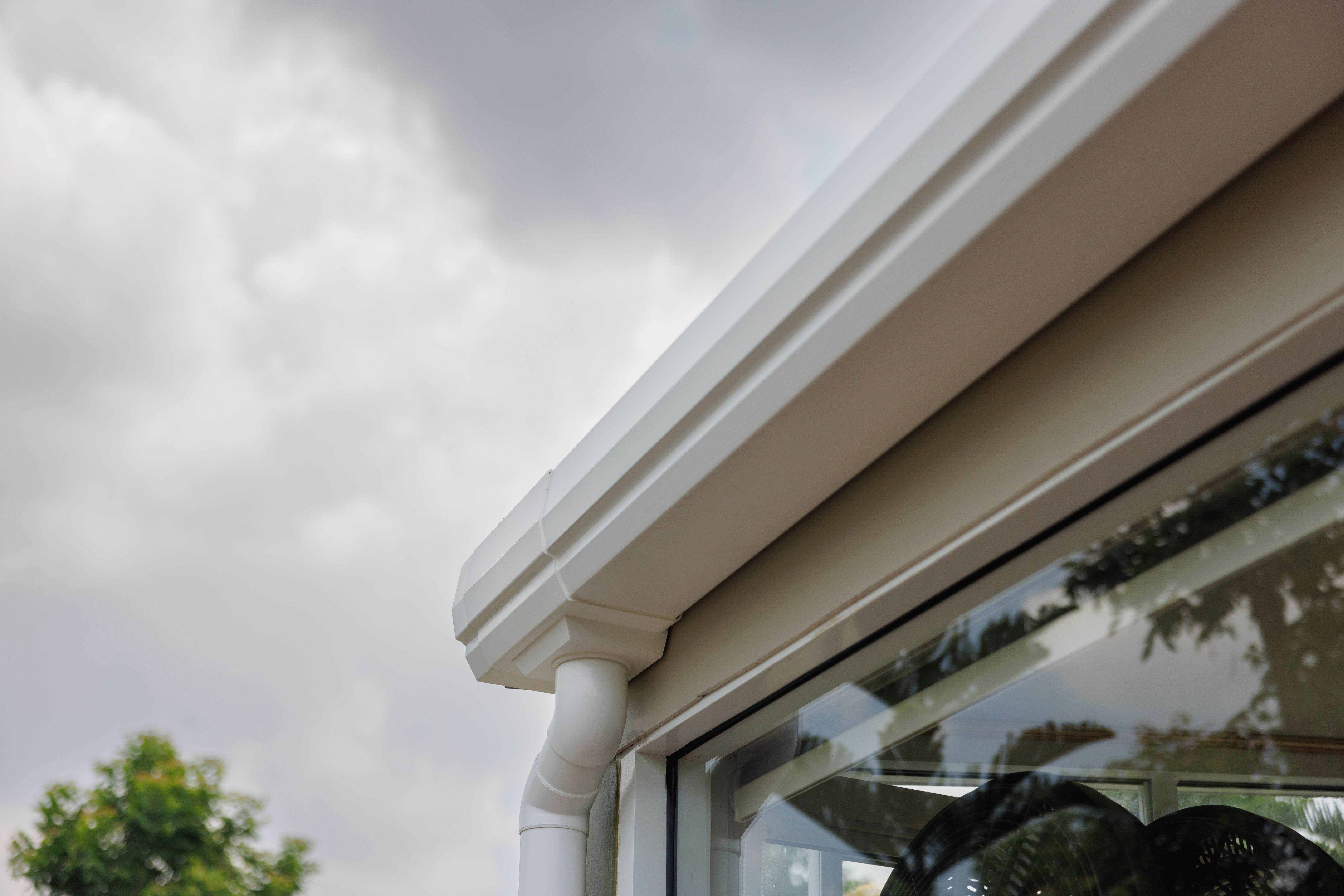 white plastic rain gutter and dark sky. concept : preparing maintenance rain gutter before rainy season.