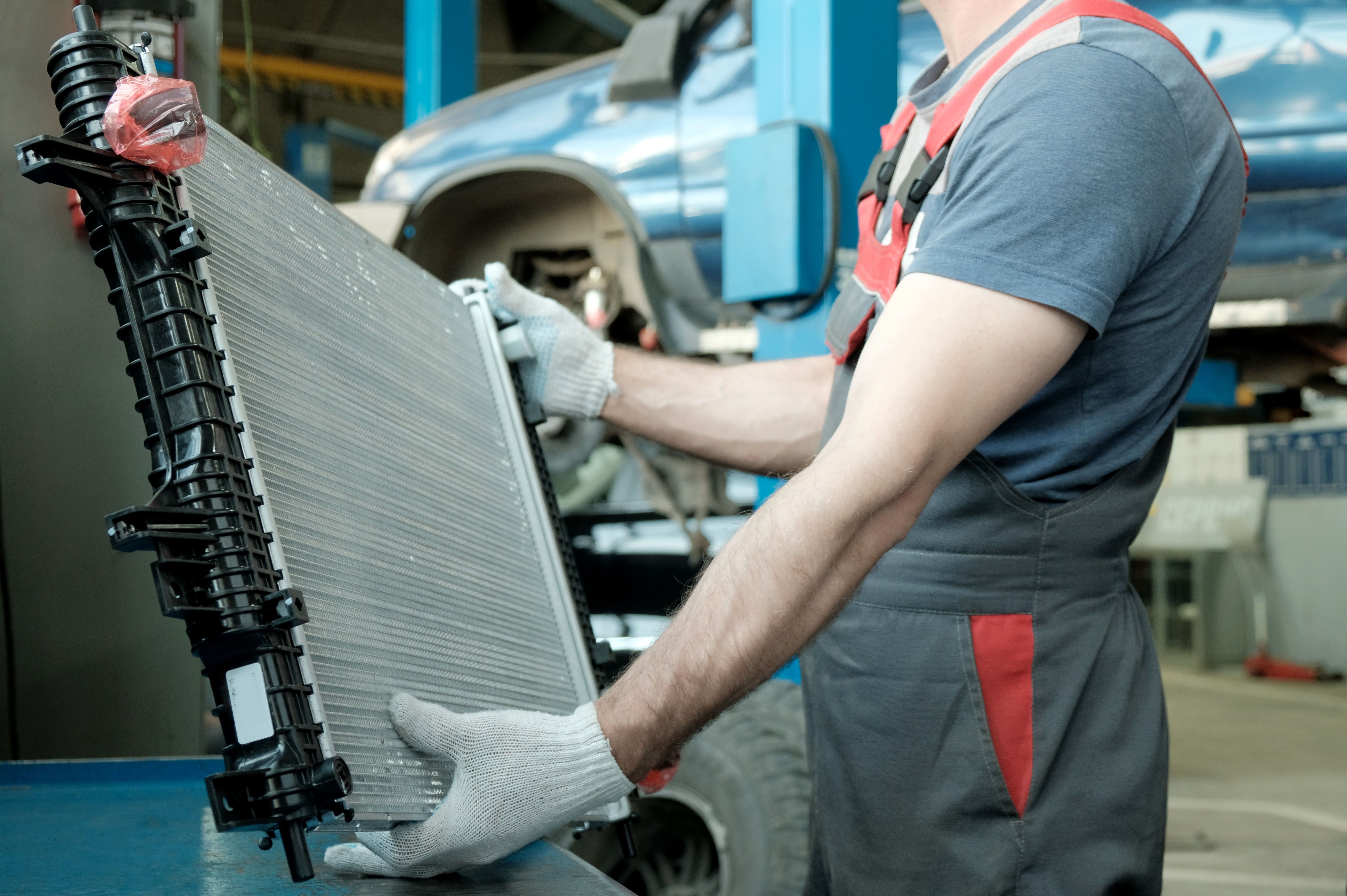 In the hands of an auto mechanic, an automobile radiator.