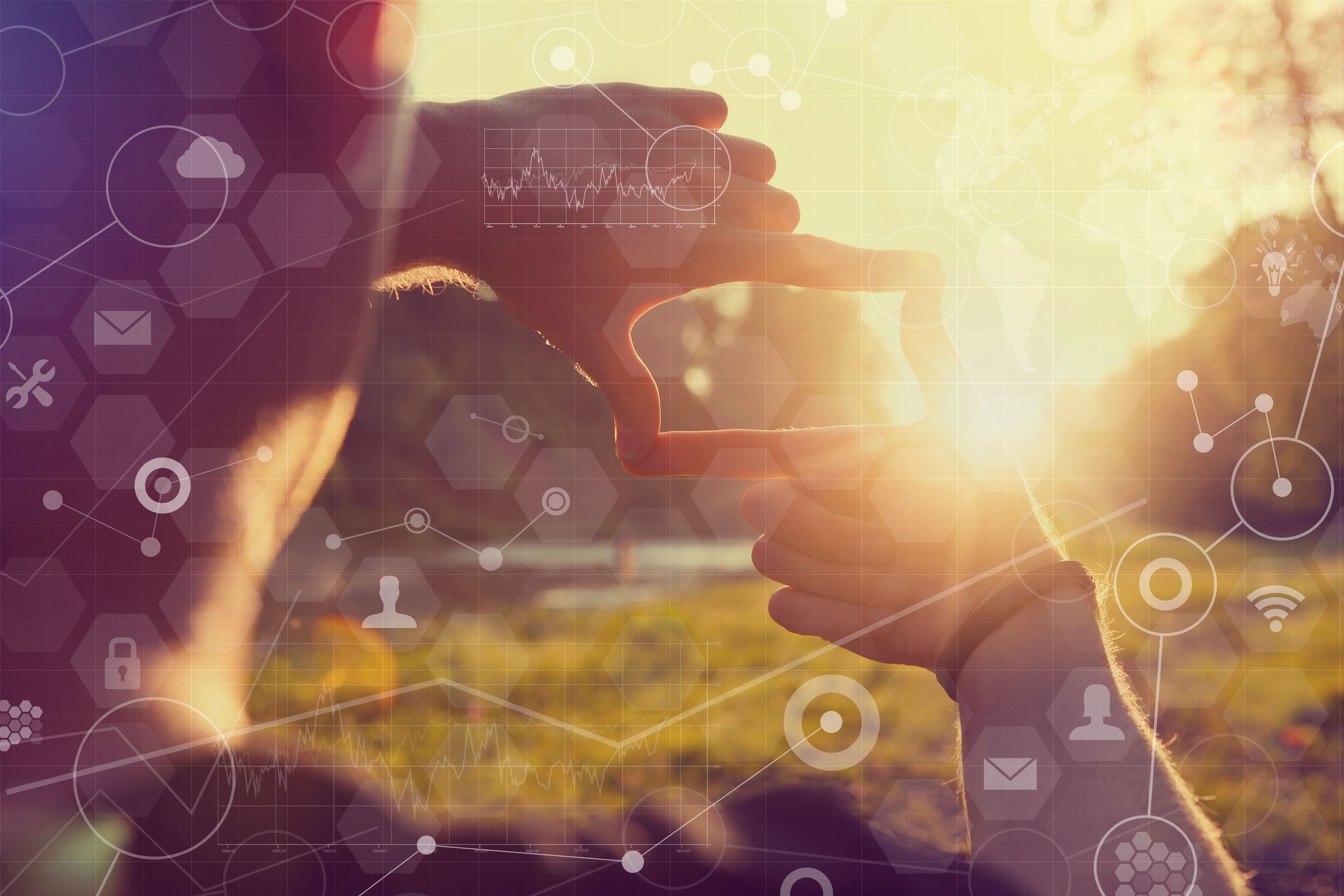 Human hands framing distant sun rays