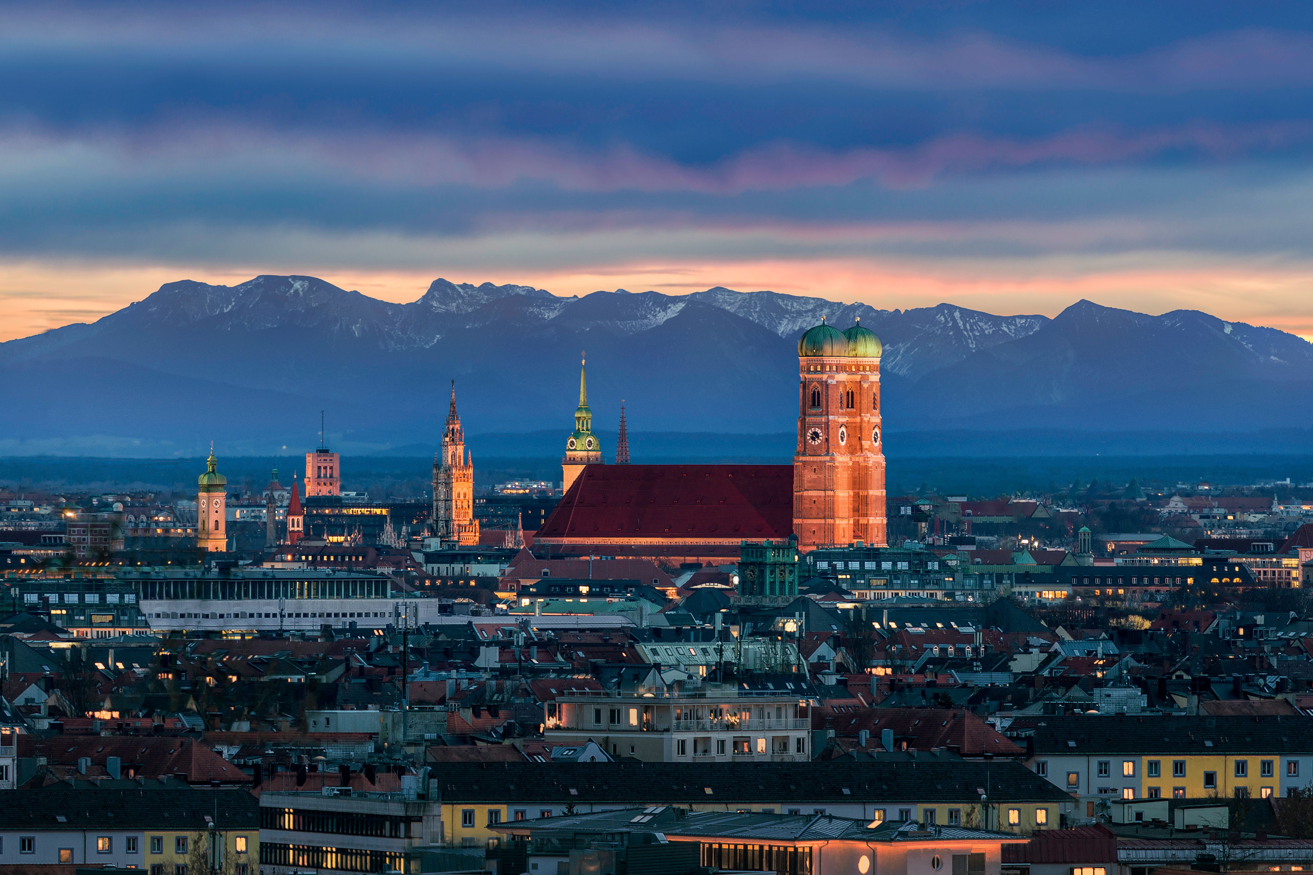 München in der Dämmerung - Berge deutscher Alpen hinter der Frauenkirche München in der Dämmerung - Berge deutscher Alpen hinter der Frauenkirche