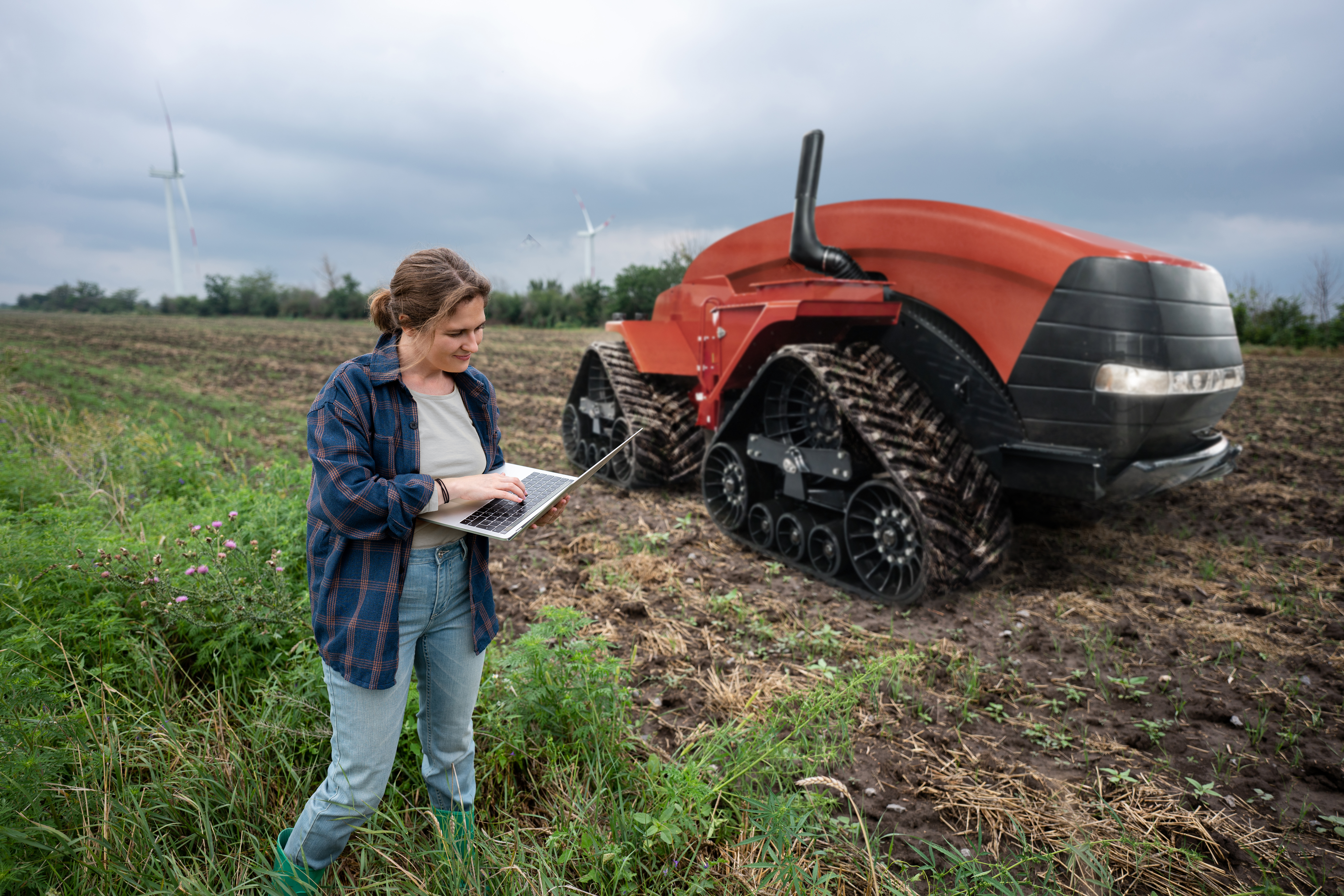 Farmer with digital tablet controls an autonomous tractor Farmer with digital tablet controls an autonomous tractor