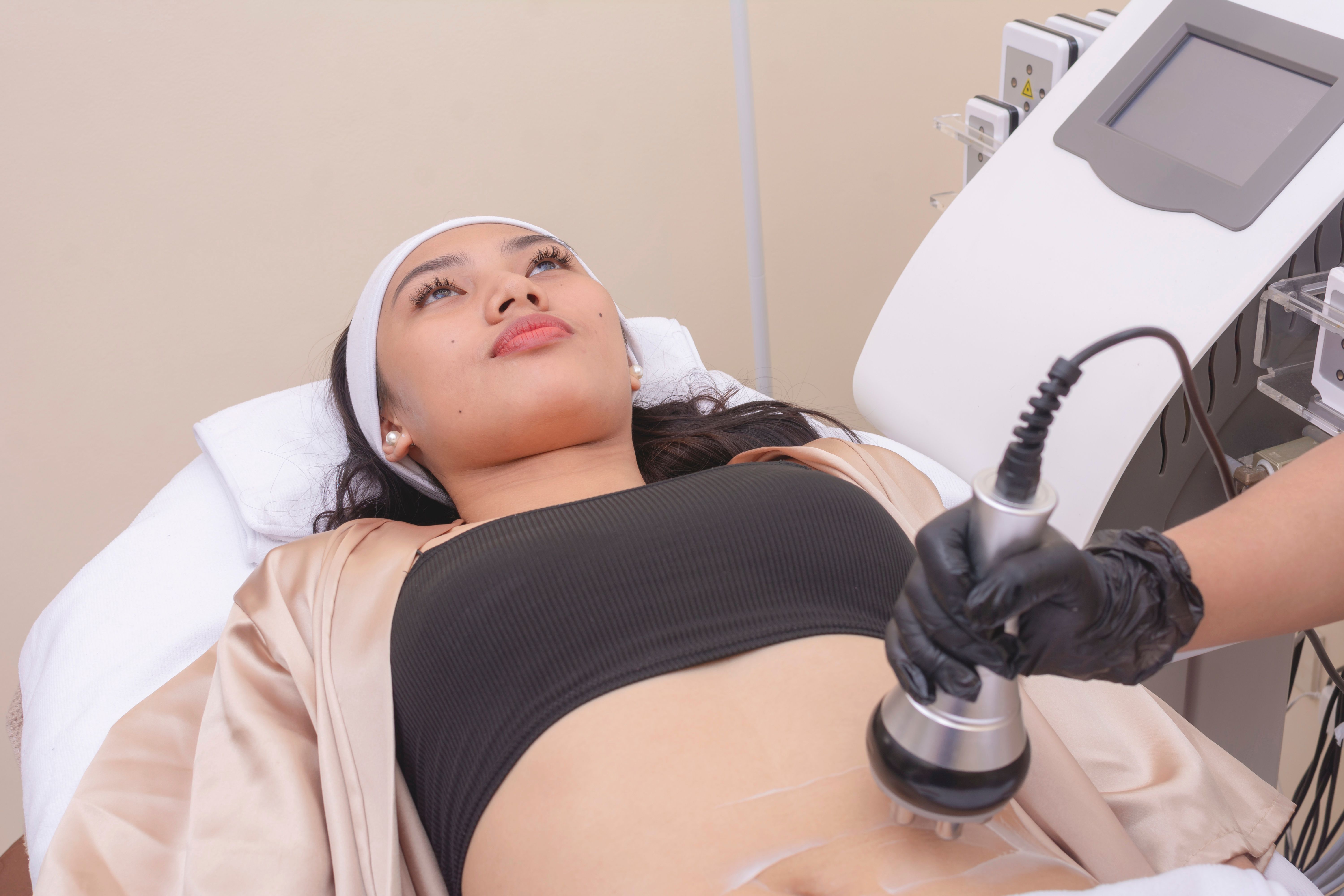 Using an RF electromagnetic device for radiofrequency abdomen tightening or waist slimming treatment. At a skin care, dermatologist or aesthetic clinic.