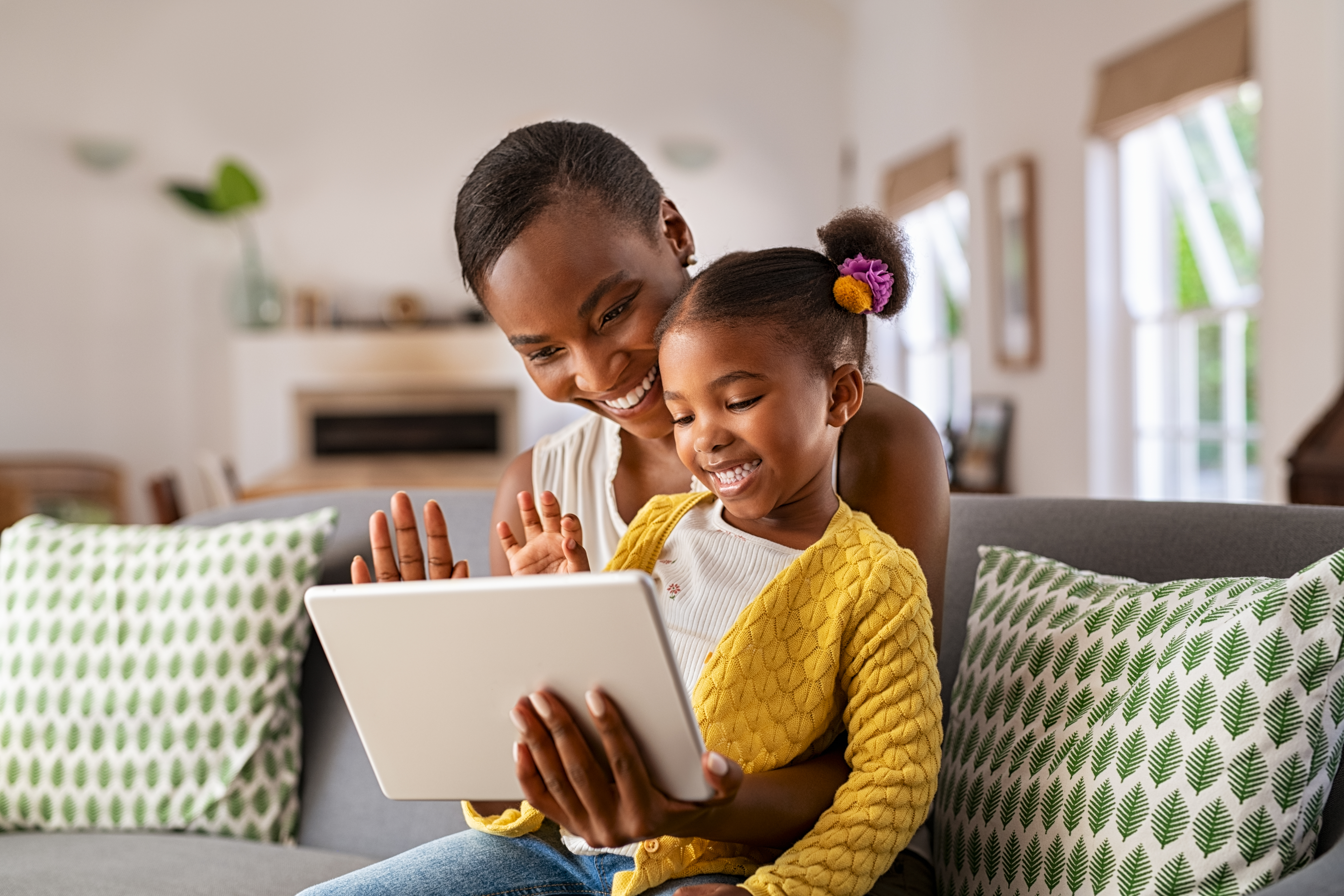 Cute little daughter and african mother using digital tablet to do a video call Cute little daughter and african mother using digital tablet to do a video call