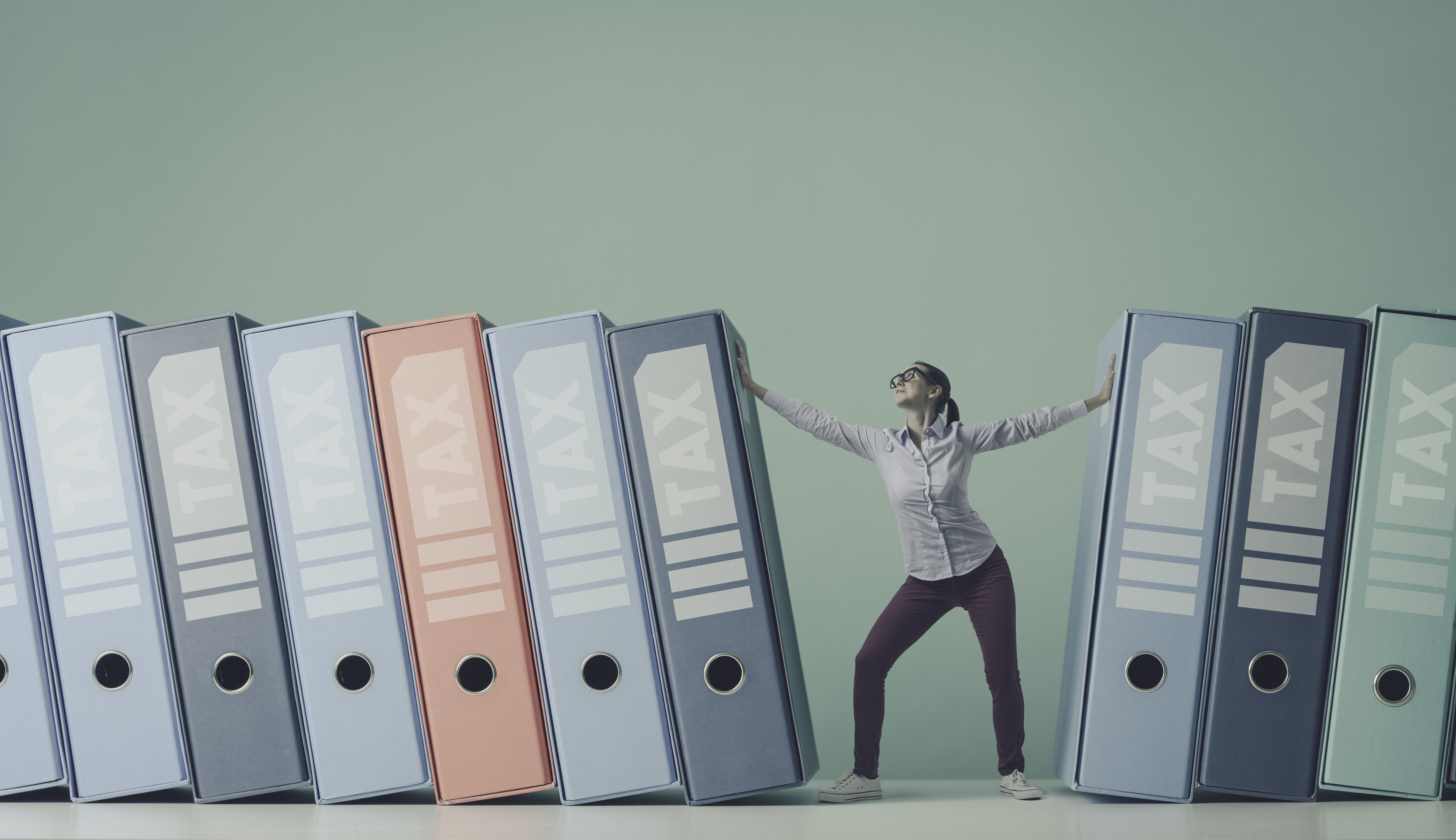 Businesswoman pushing away ring binders with tax forms