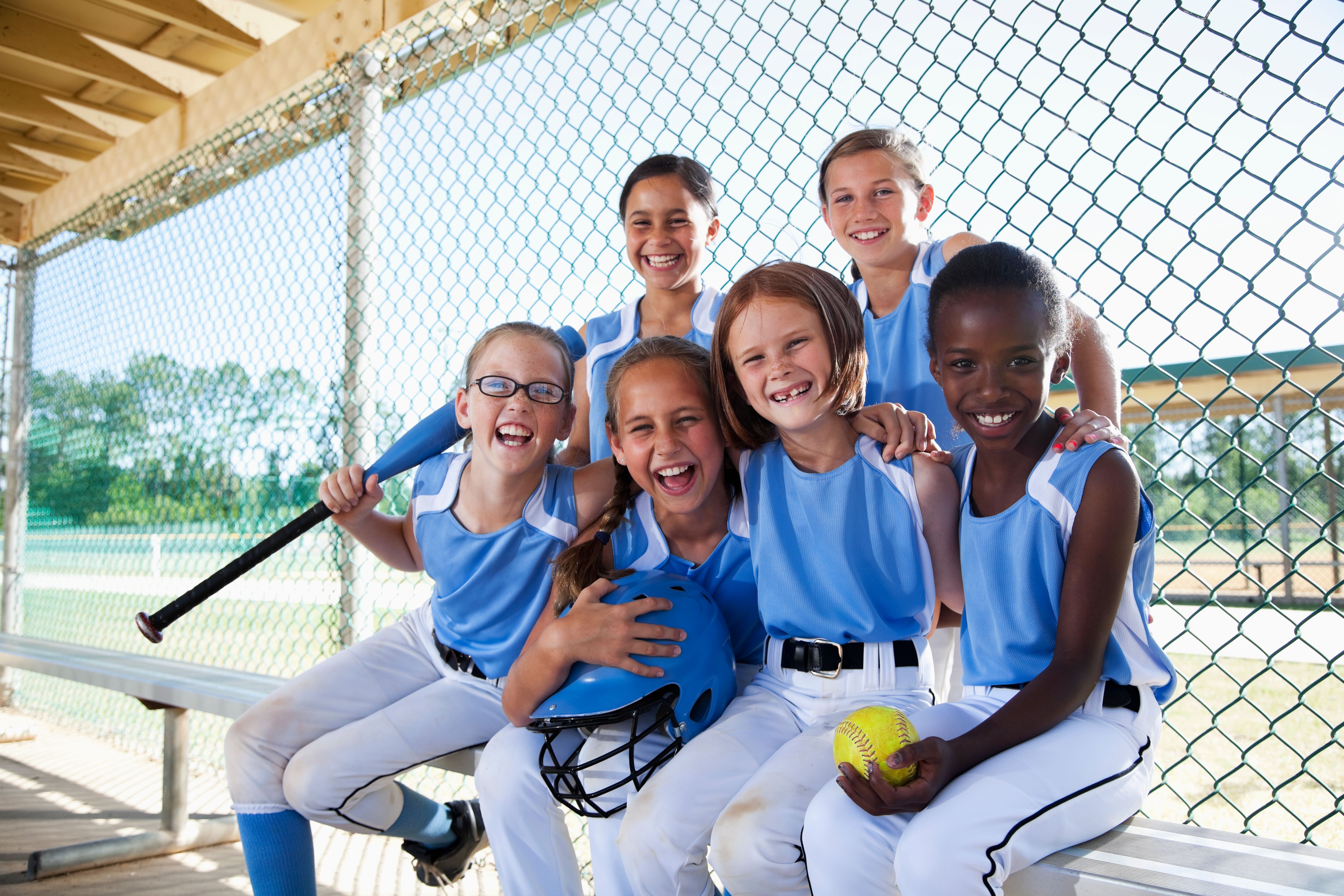 Girls softball team sitting in dugout
