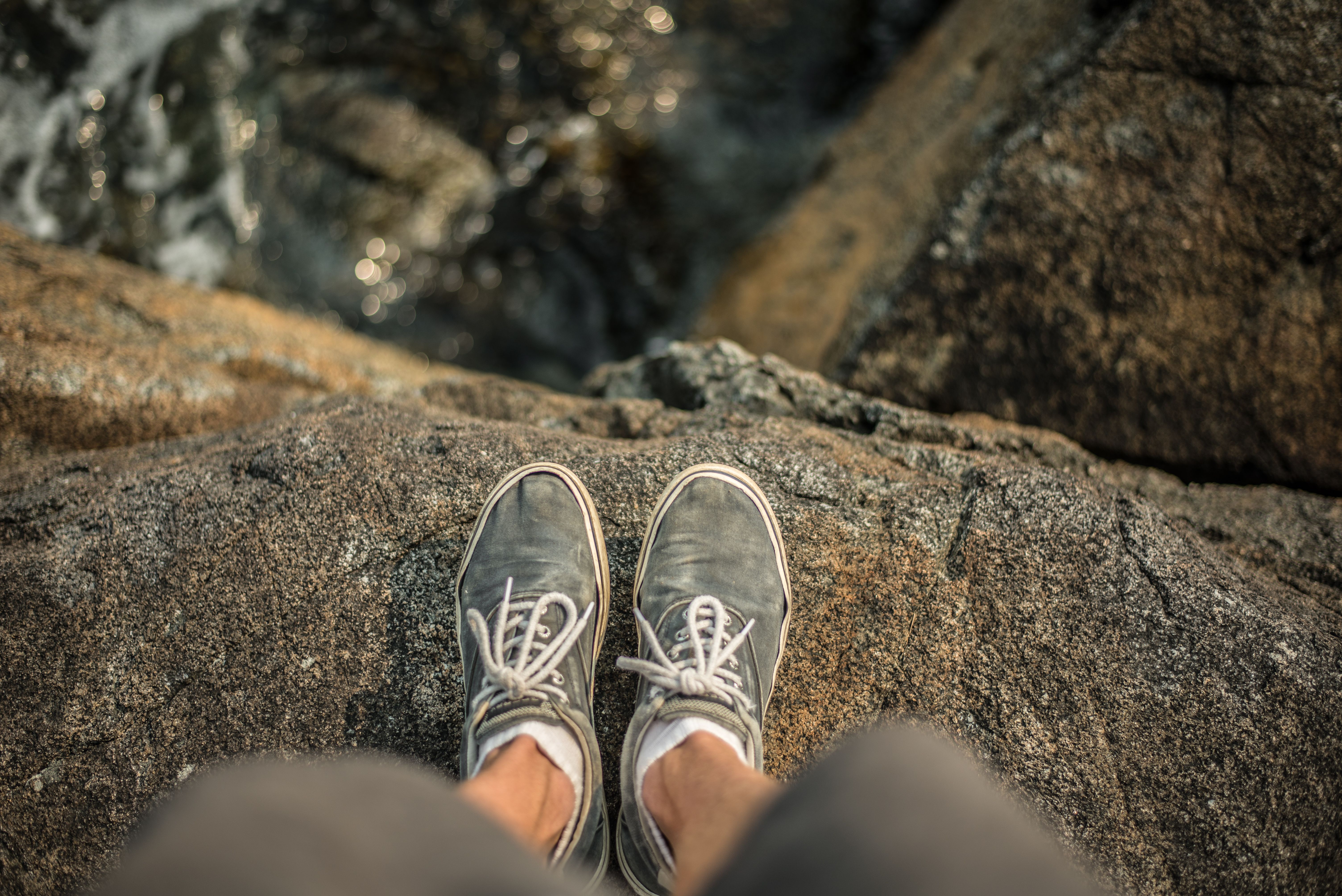 Shoes standing on the edge of cliff over ocean