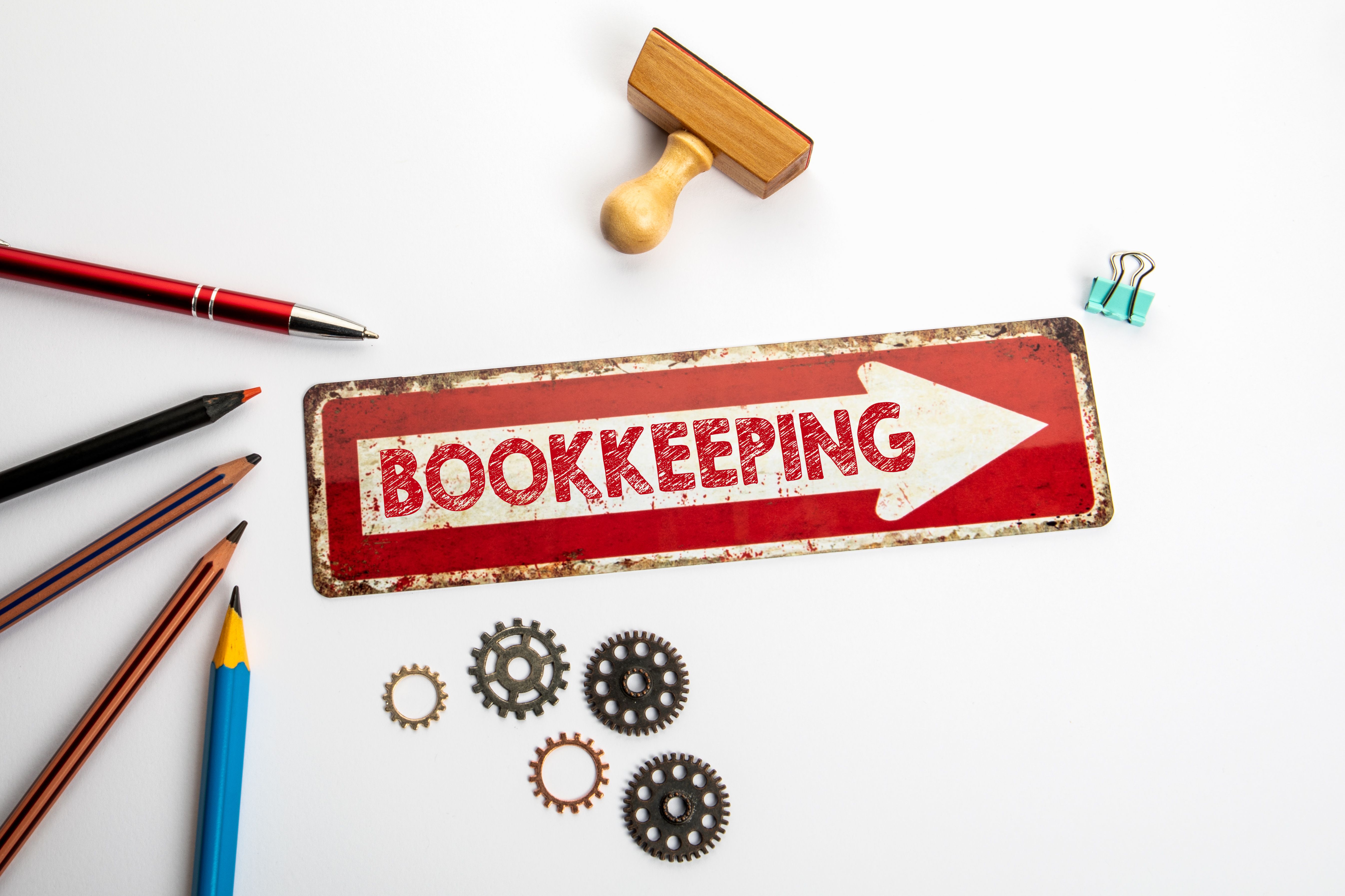 Bookkeeping. Red direction arrow with text on white office desk