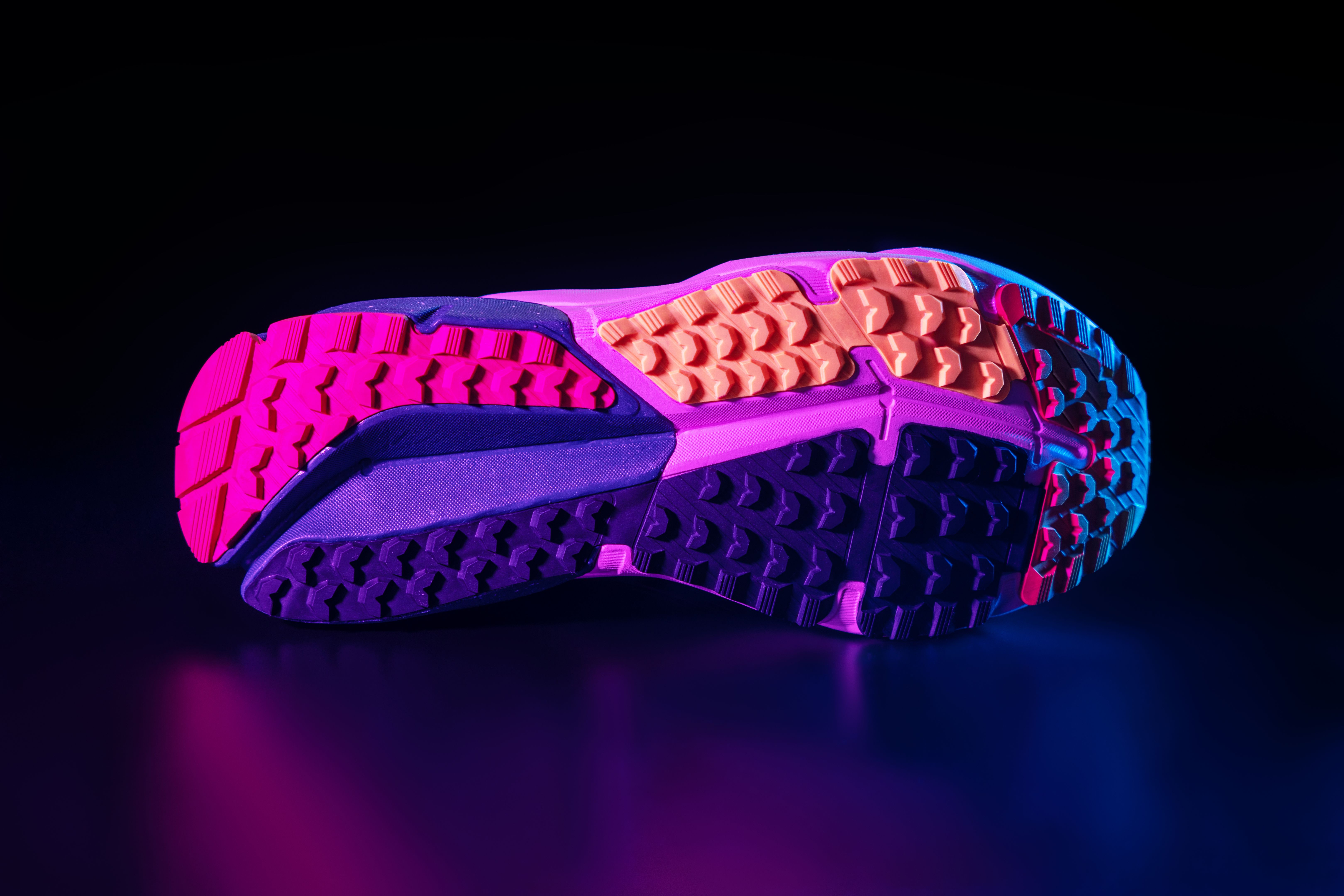 A sole of running shoe isolated on black background in neon coloured lighting