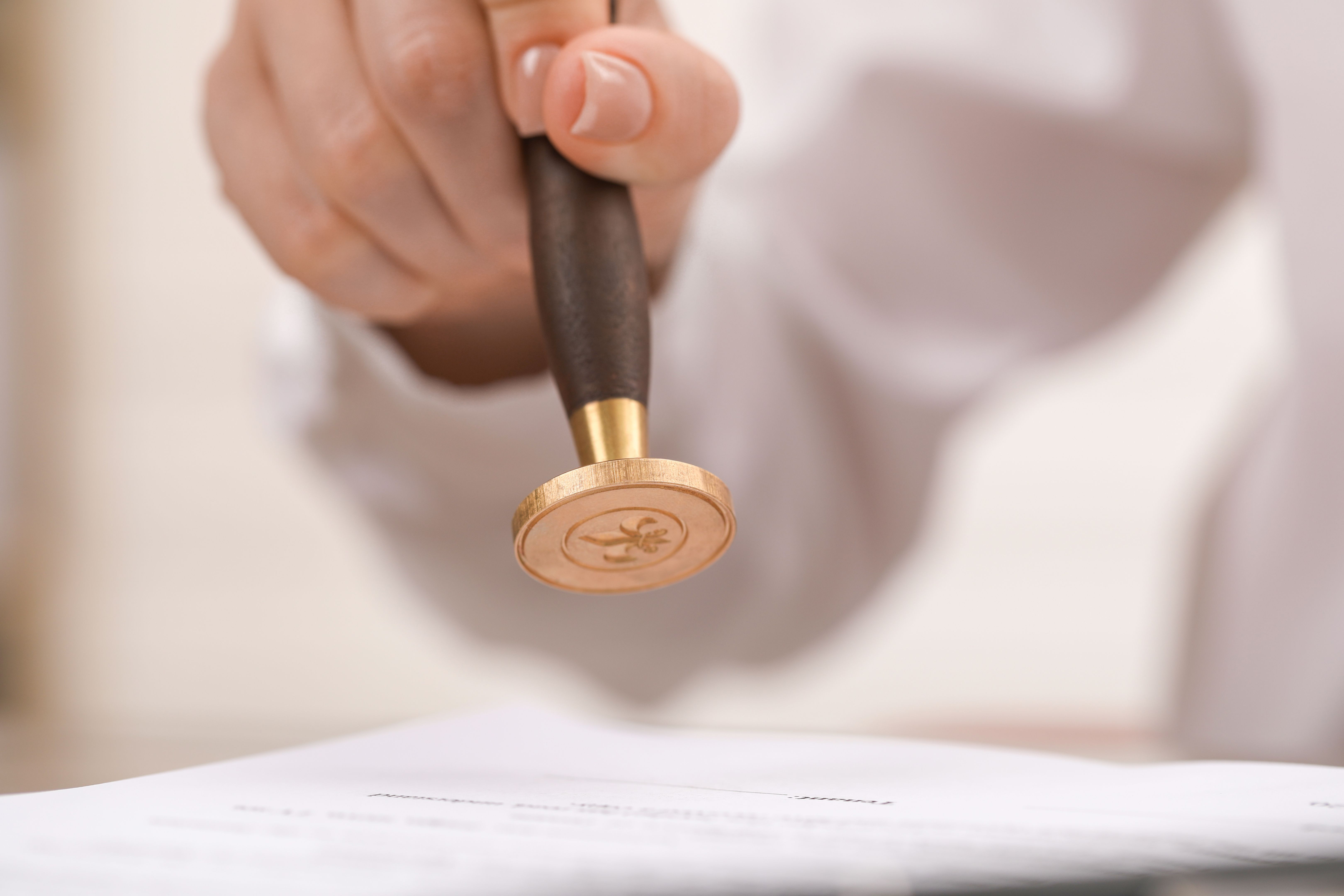 Woman stamping document at table, closeup view
