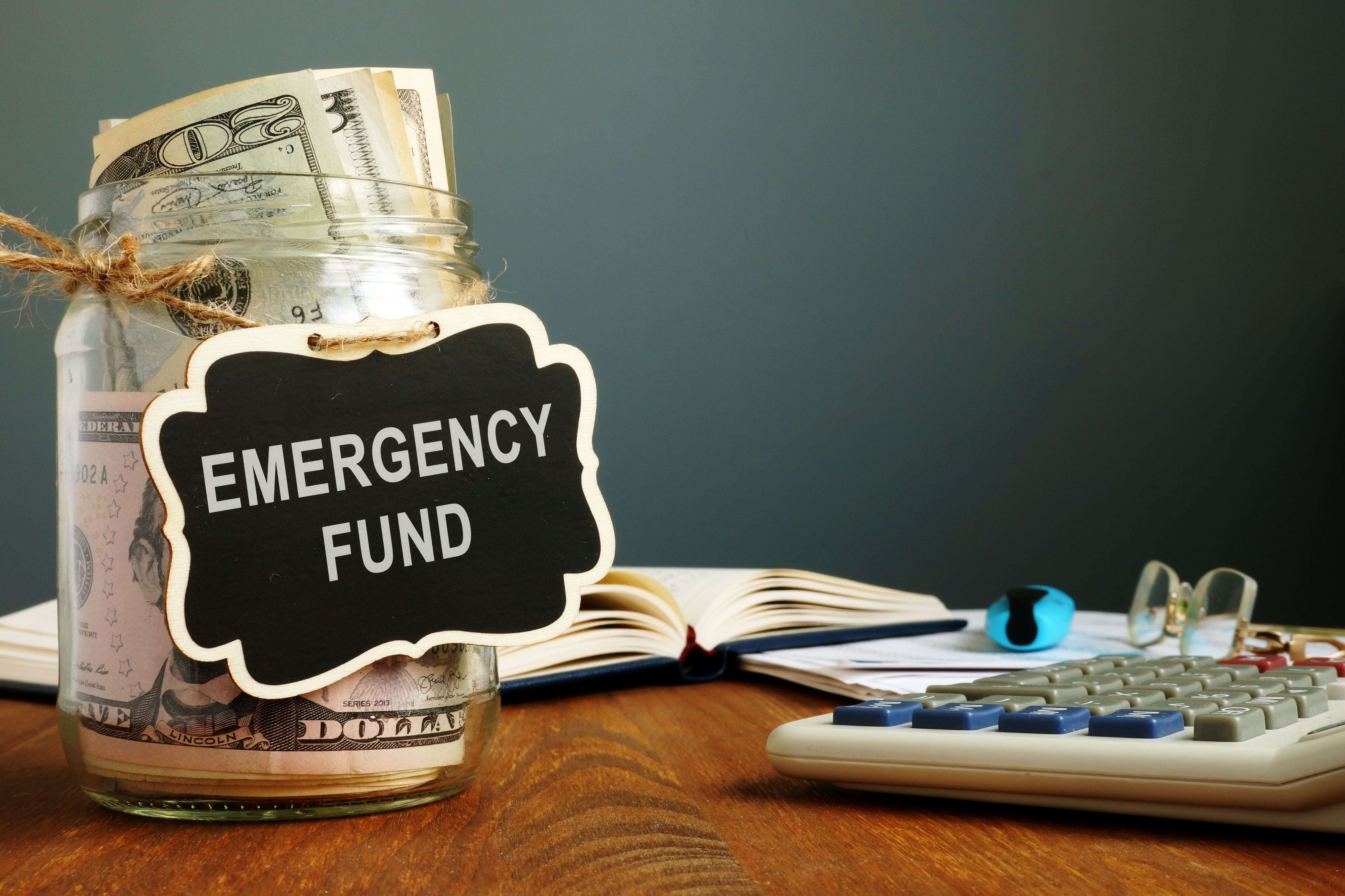 Emergency fund savings written on the jar with money. Emergency fund savings written on the jar with money.