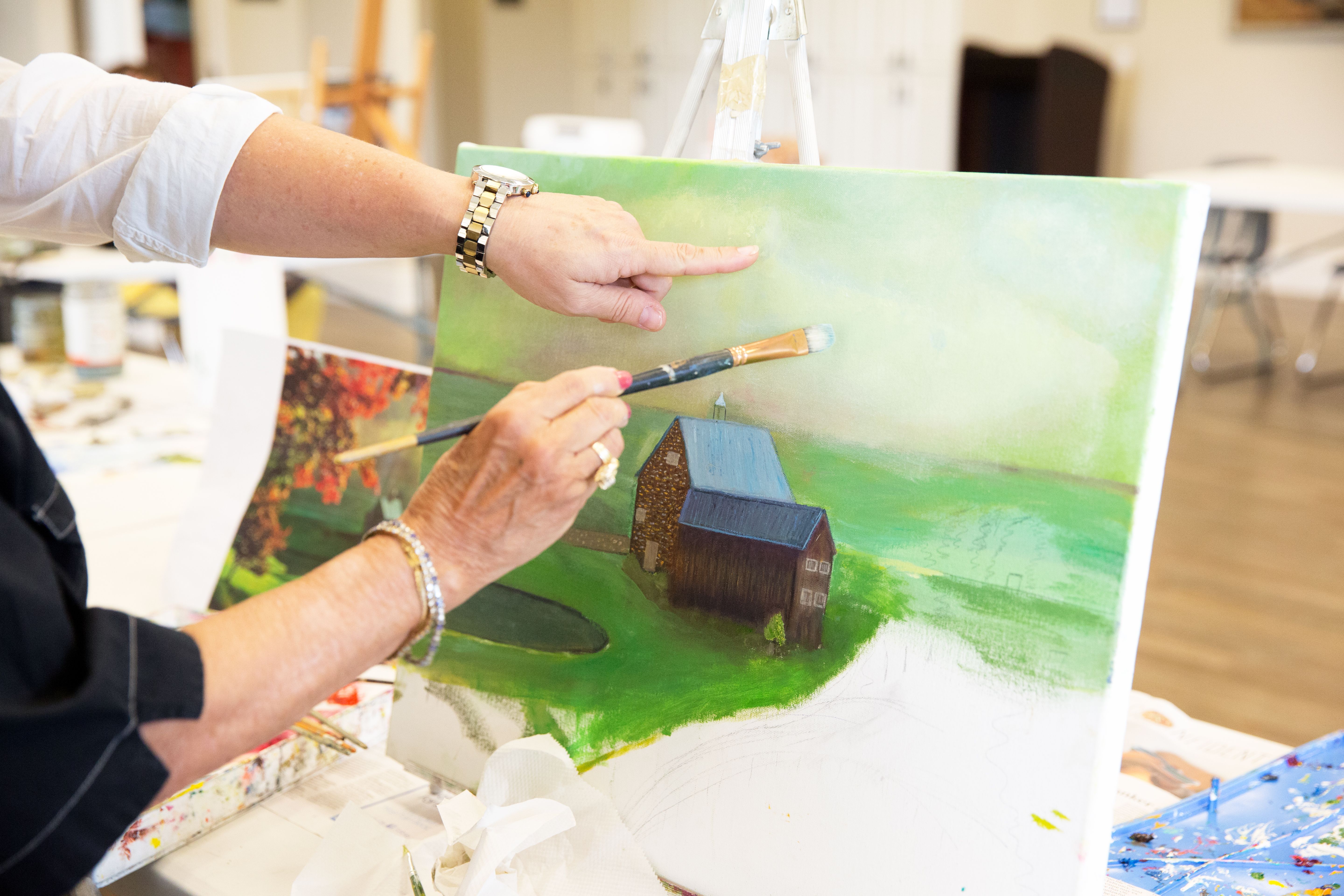 Senior citizen painting in art class