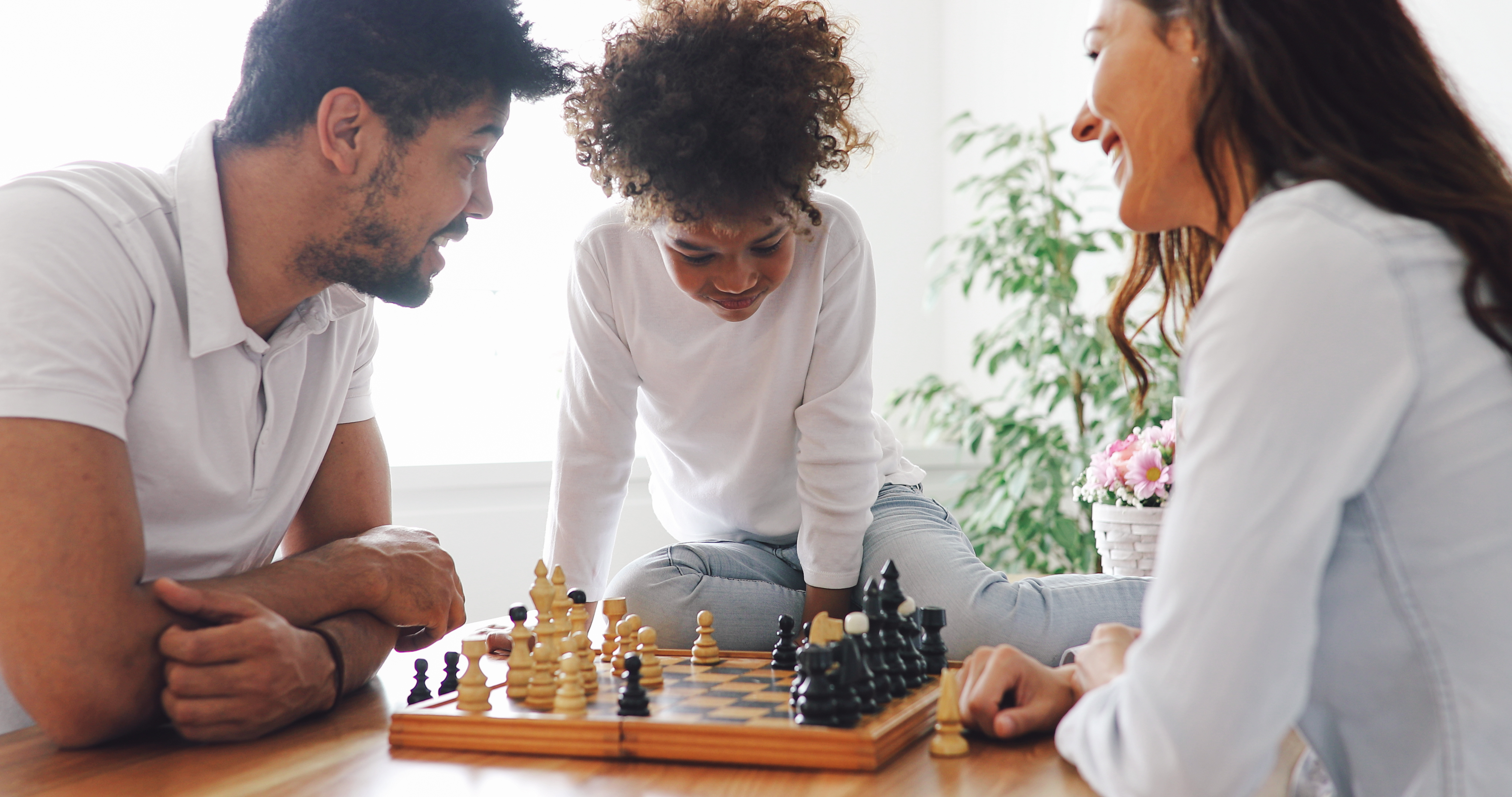 Happy family playing chess together at home
