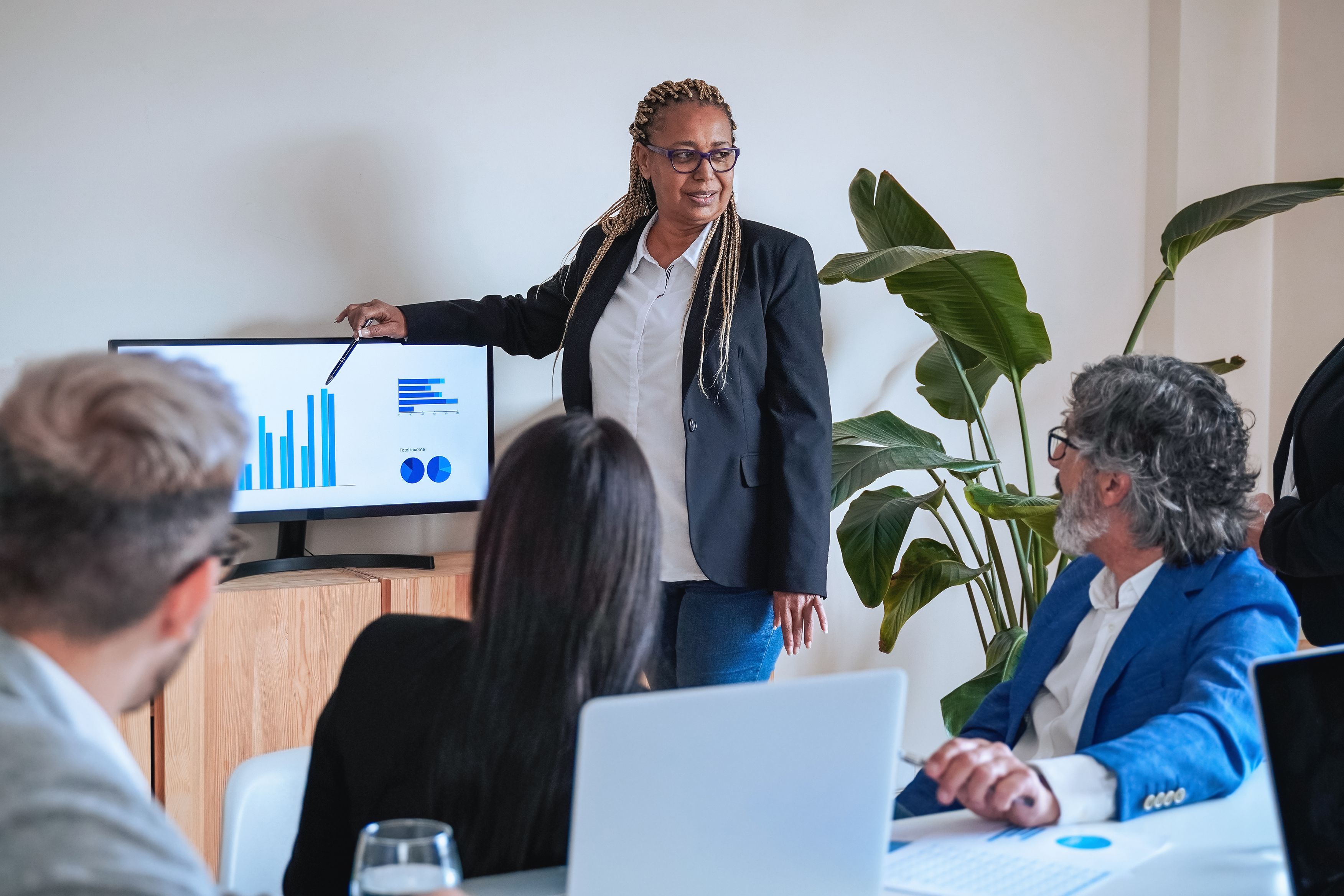 Multiethnic business people working on finance project meeting inside bank office - Focus on African senior woman face Multiethnic business people working on finance project meeting inside bank office - Focus on African senior woman face