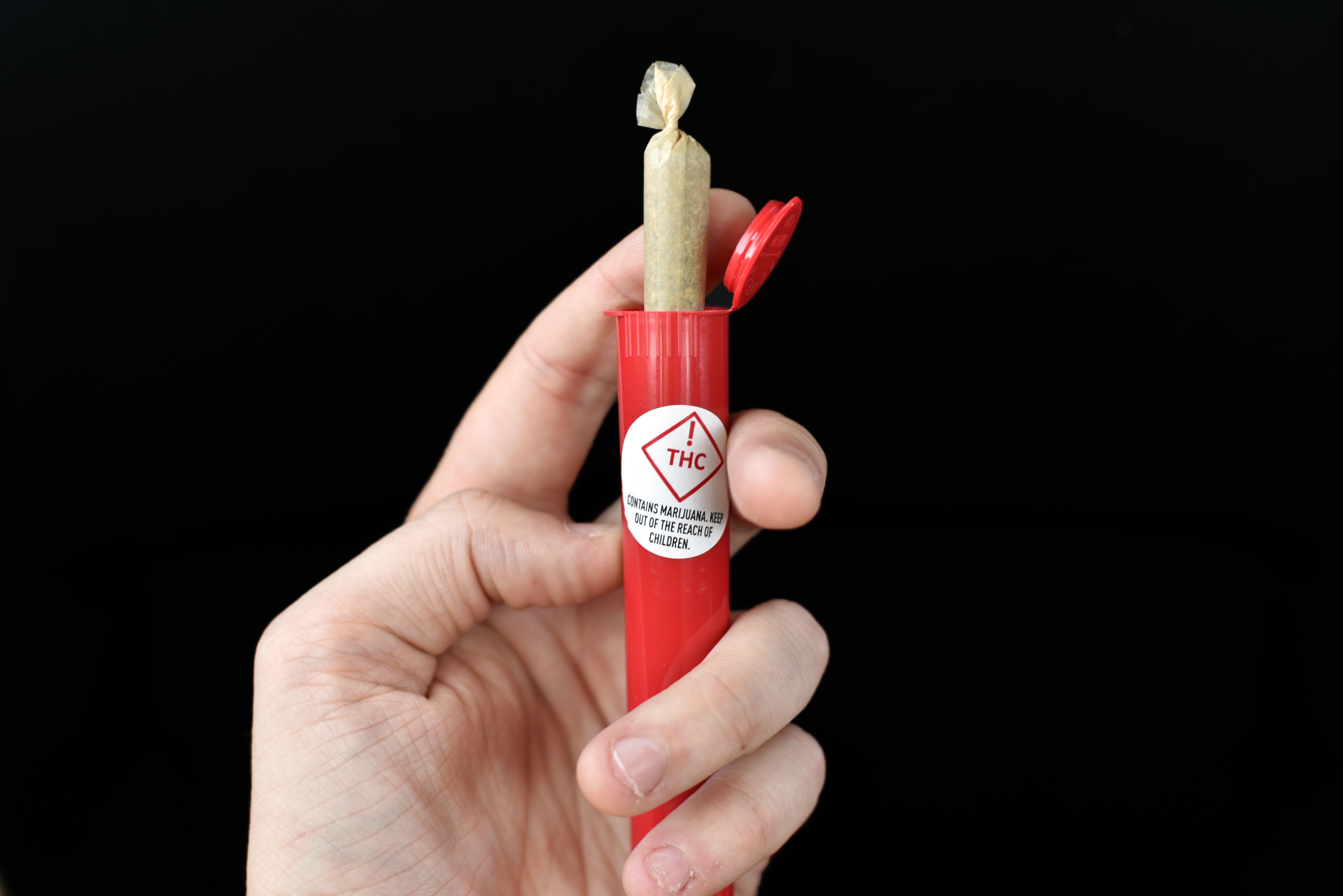 Red THC warning with marijuana joint container