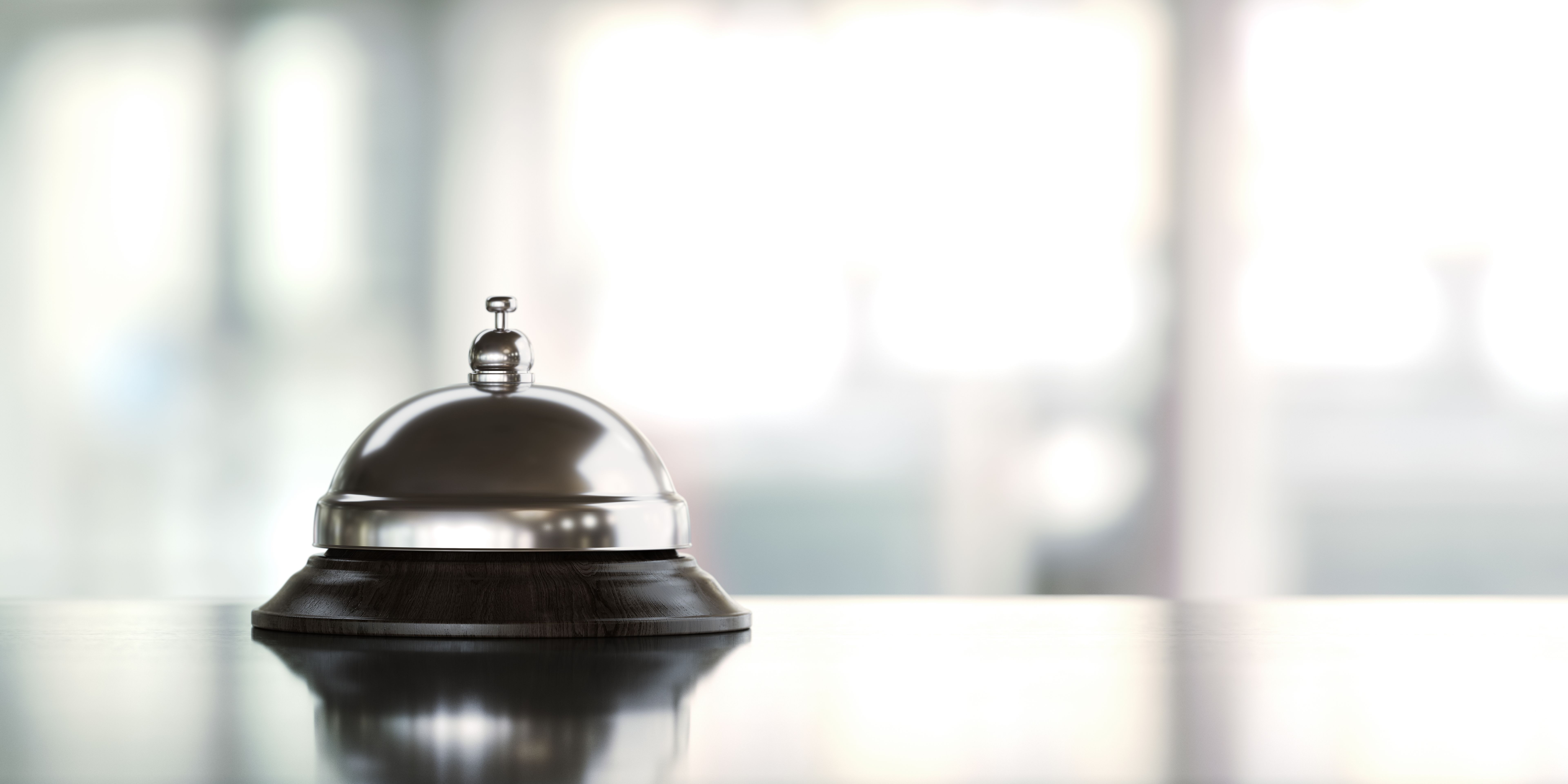 A polished service bell sits on a sleek countertop, symbolizing premium concierge service and seamless assistance in a well-lit, modern setting.