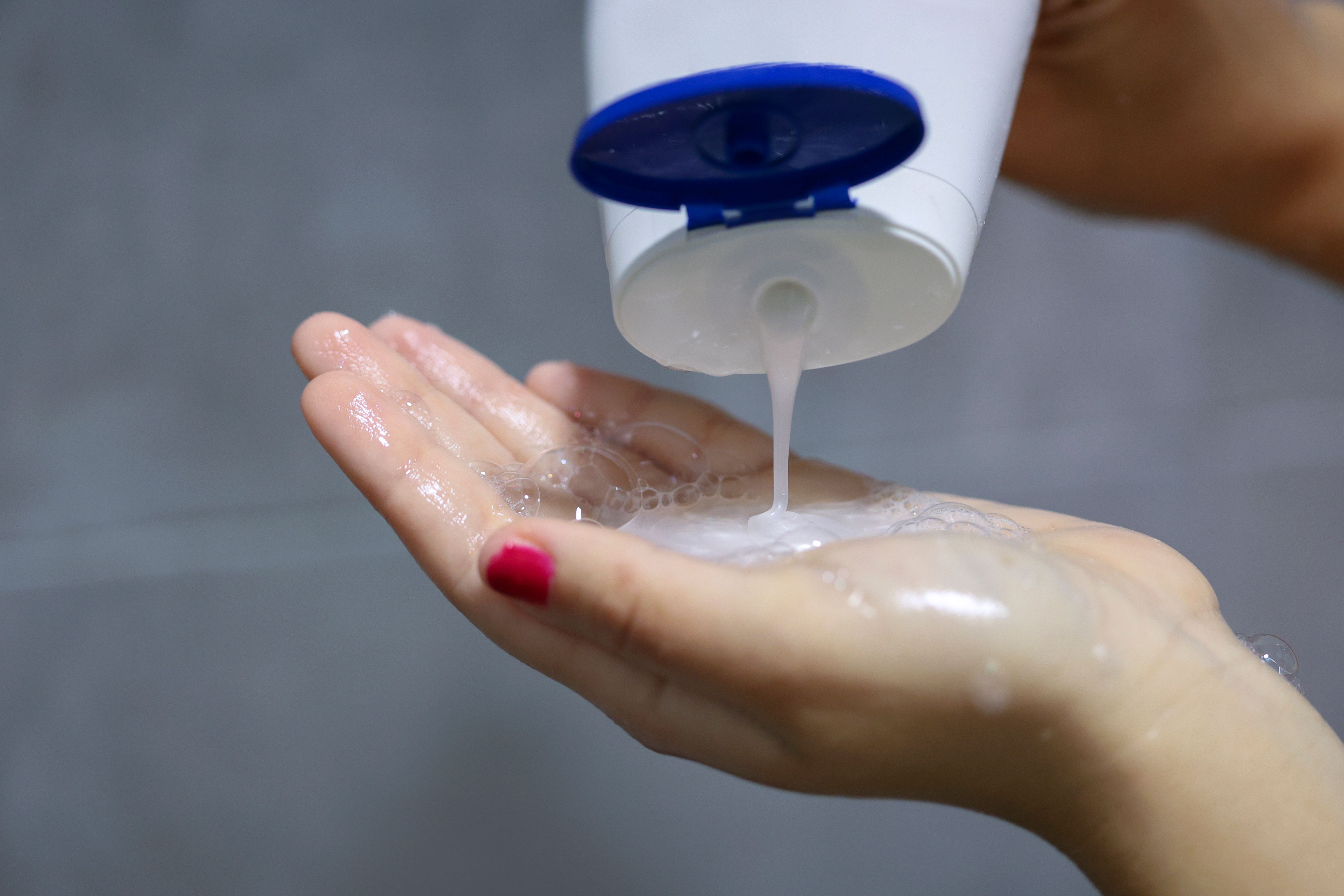 hands holding shampoo bottle