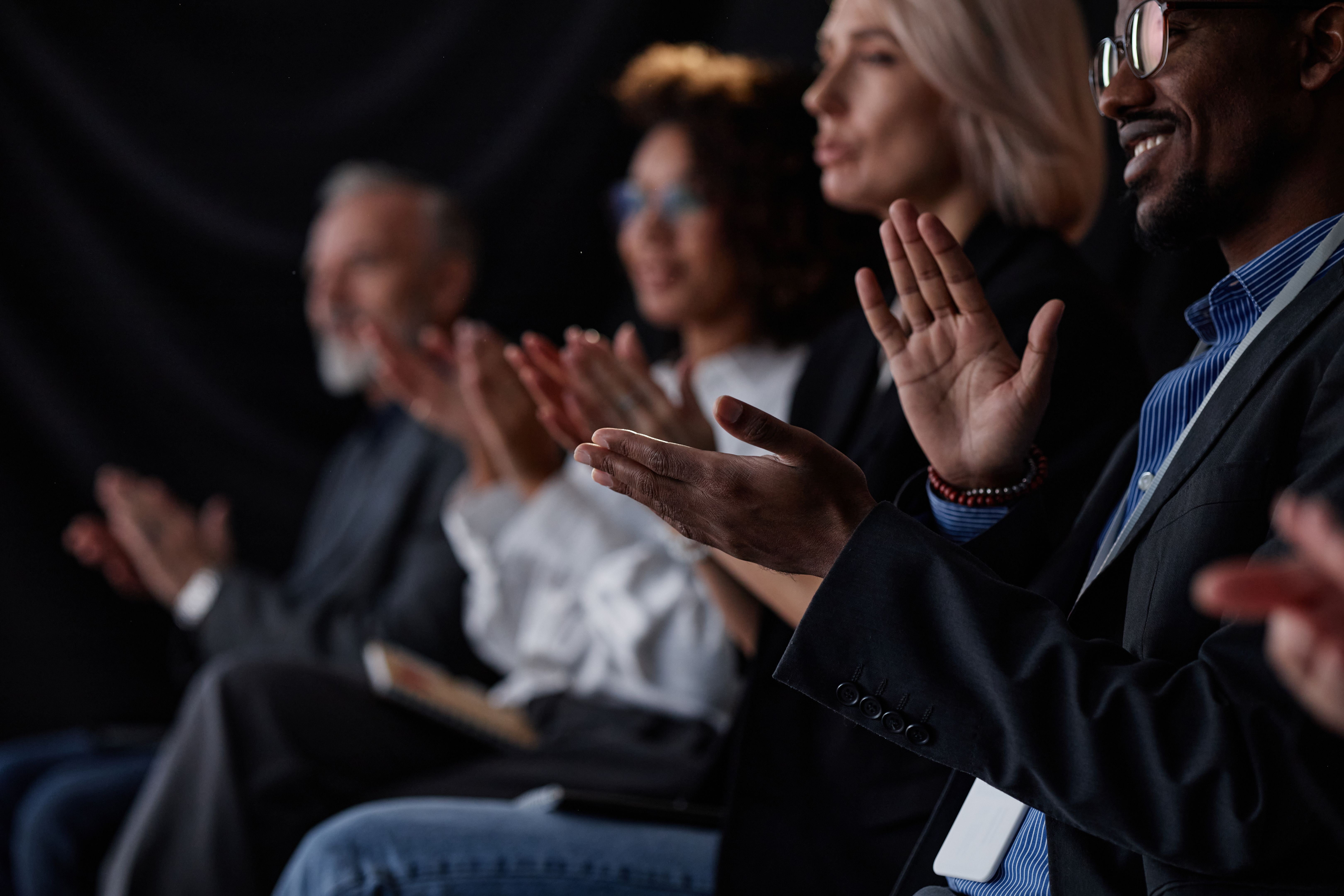 Smiling Black Man Applauding Speech at Business Conference in Auditorium