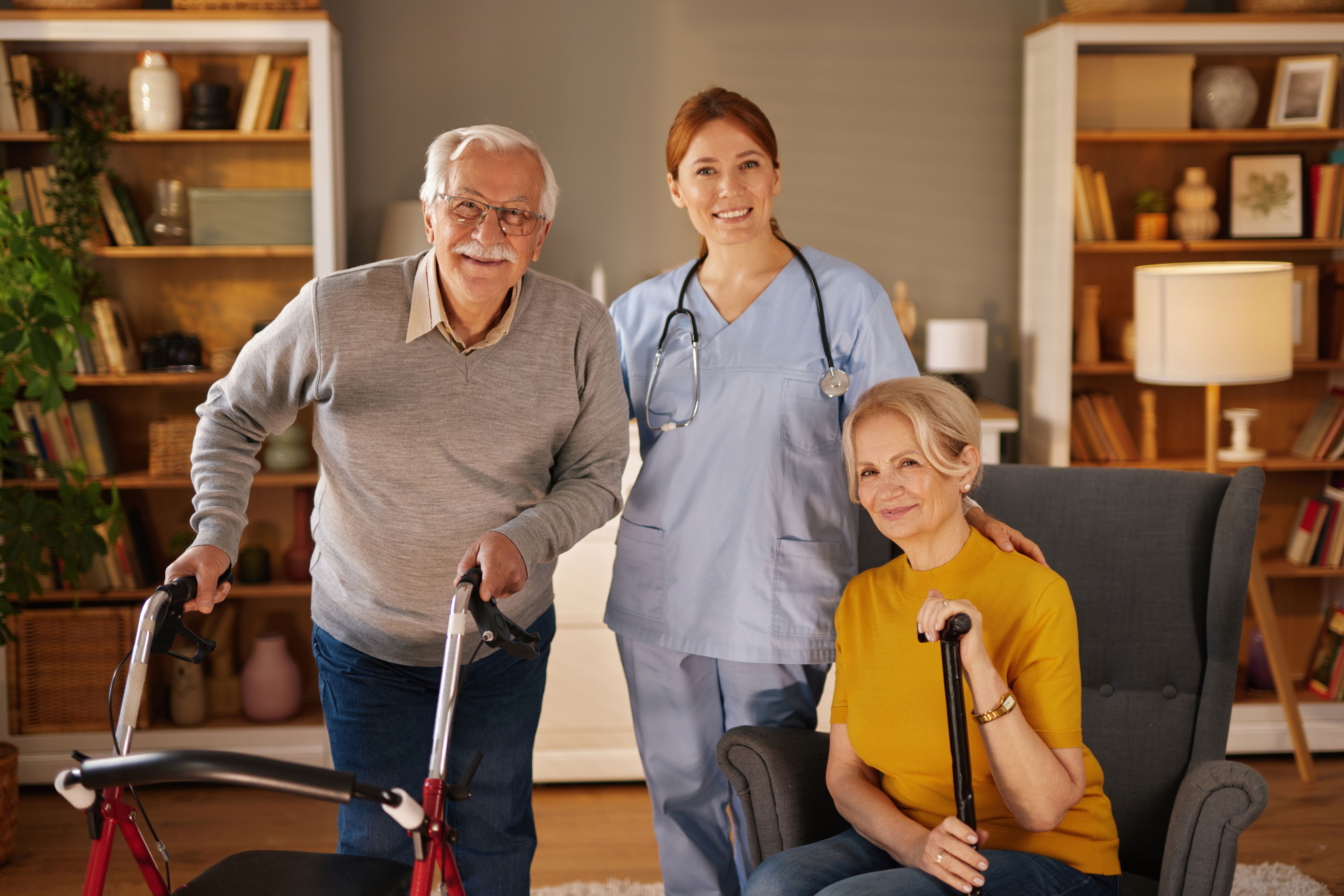 Nurse posing with elderly couple at home for healthcare