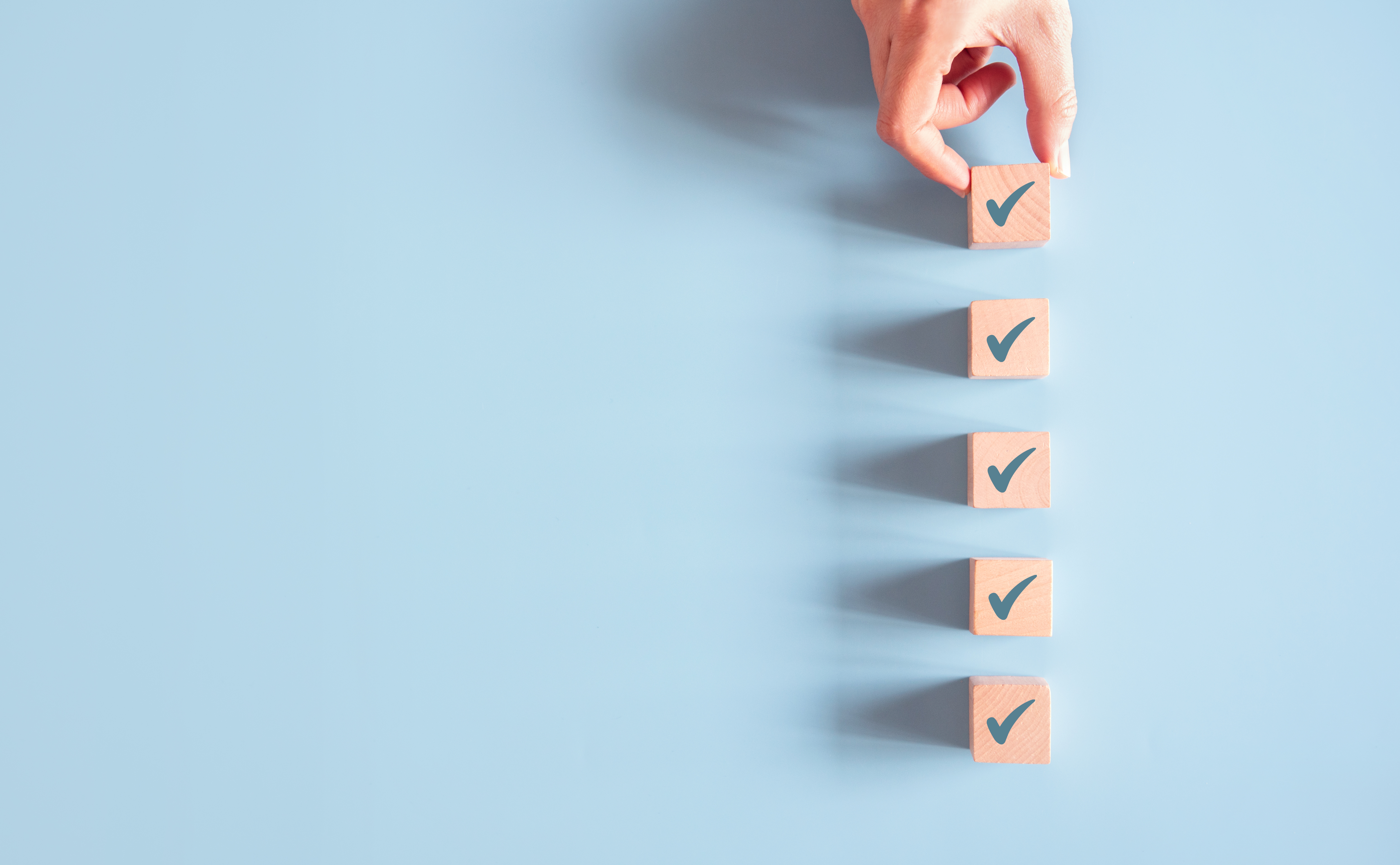 Wood cube with check mark on blue background, Checklist concept, Copy space.