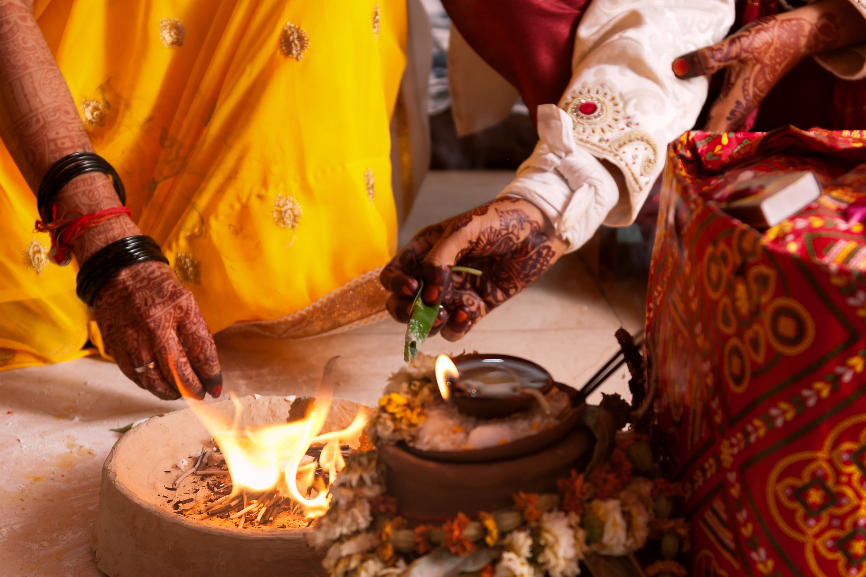 Bride and groom offering to holy fire at mandap, a typical wedding ritual during an Indian marriage. Bride and groom offering to holy fire at mandap, a typical wedding ritual during an Indian marriage.