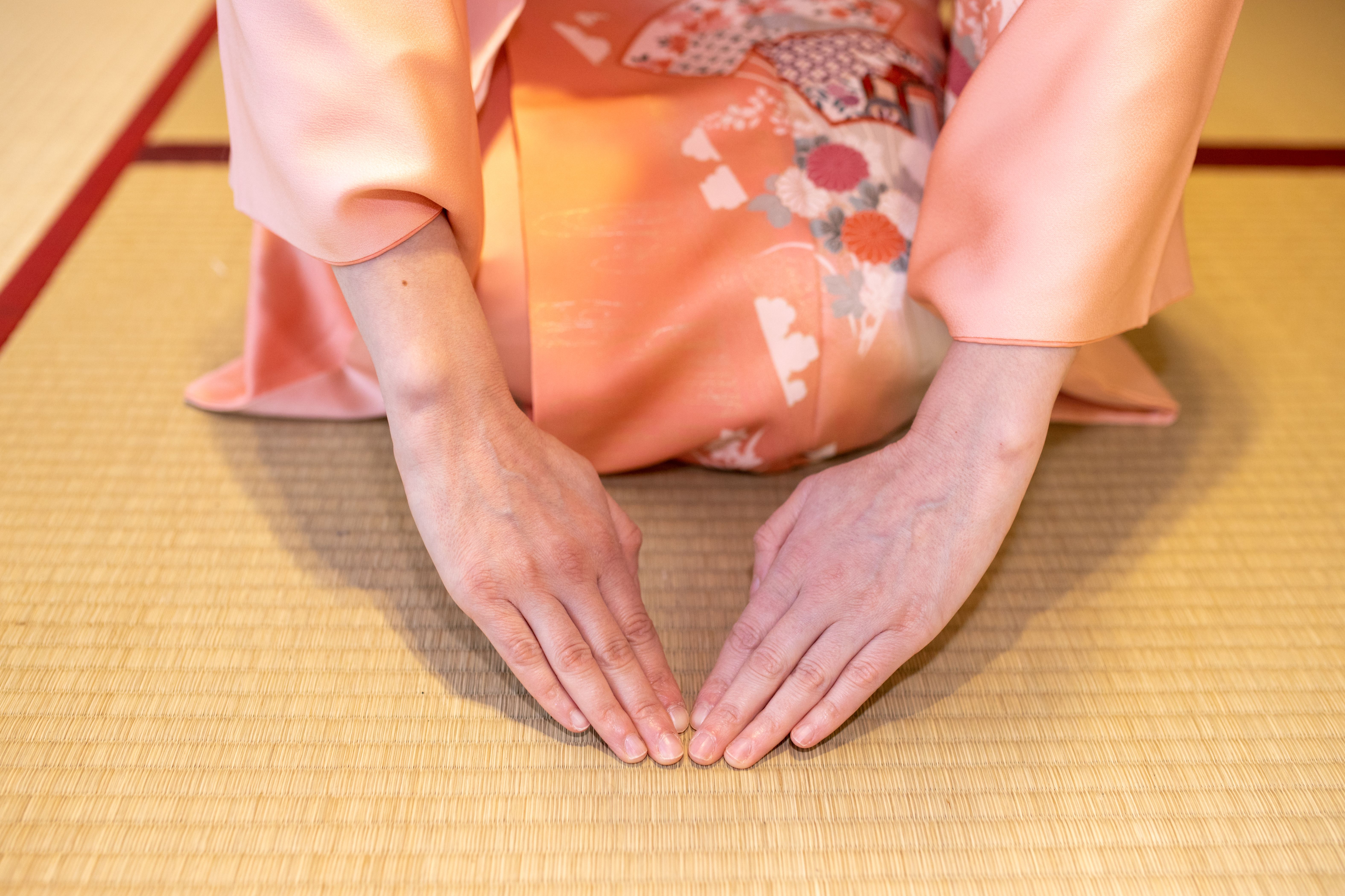 Close up of woman sitting on heels and bowing in Japanese tatami room Close up of woman sitting on heels and bowing in Japanese tatami room