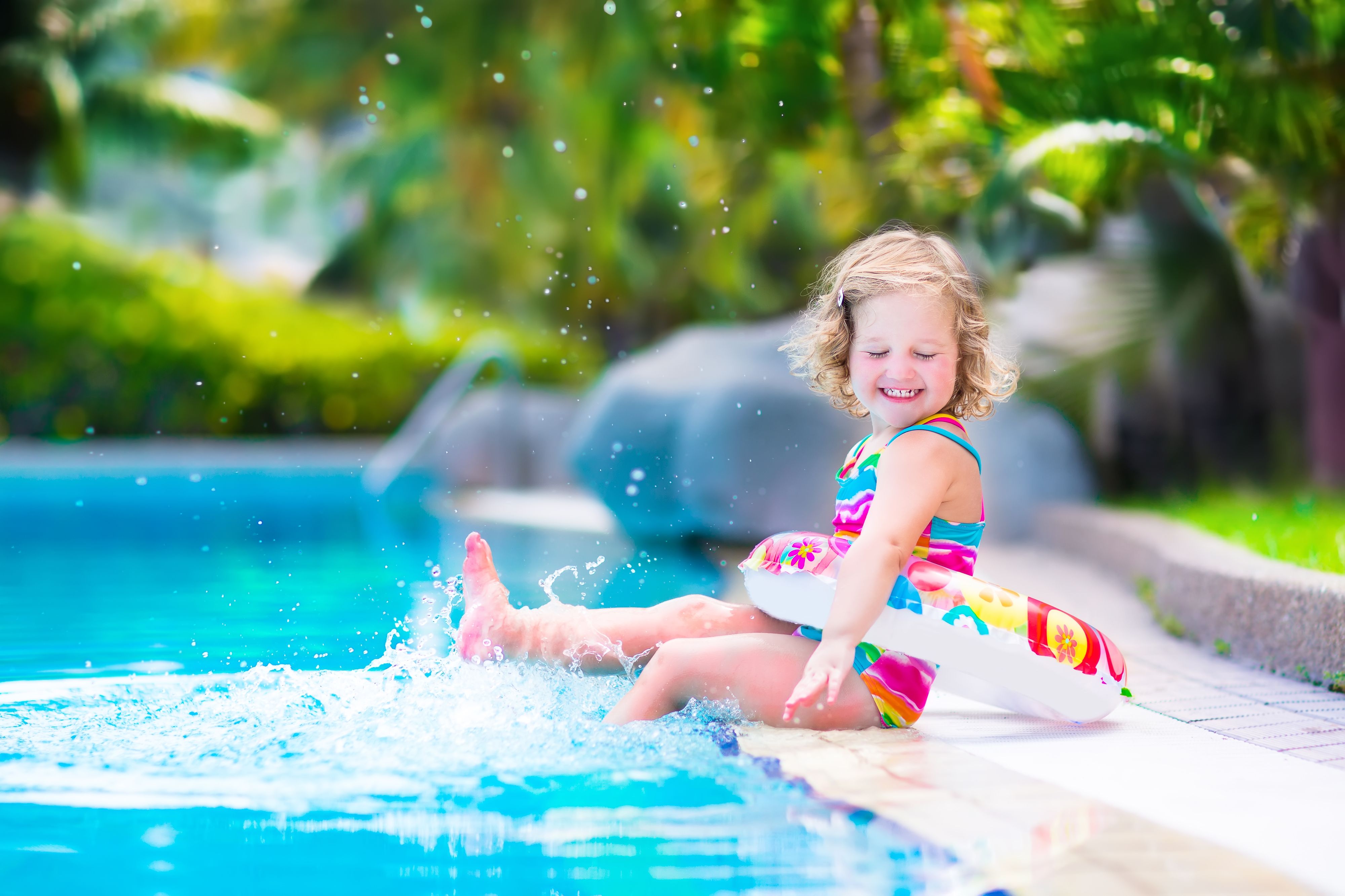 Little happy girl in a swimming pool