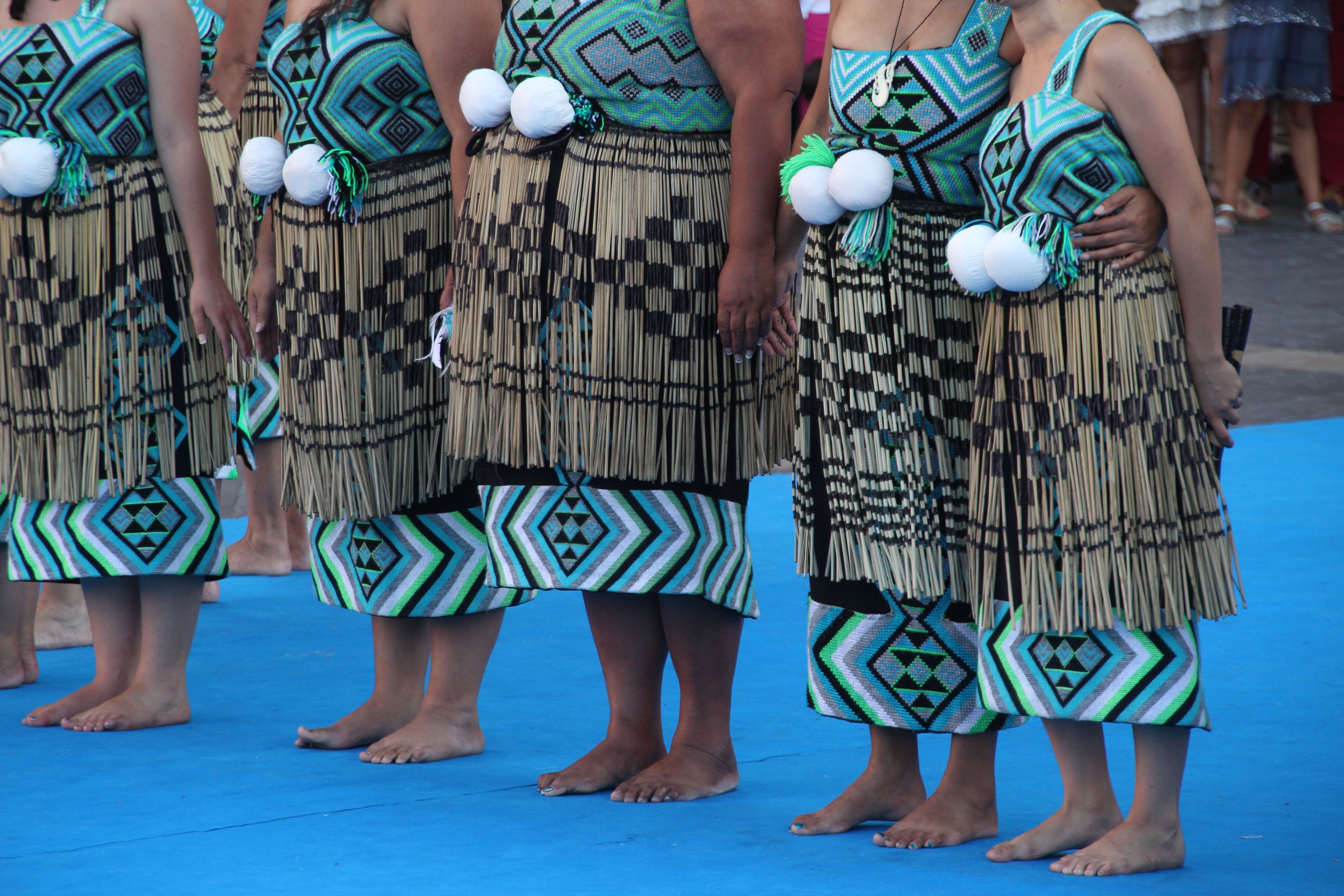 Group of New Zealand Maori folk dancers performing in an outdoor festival.