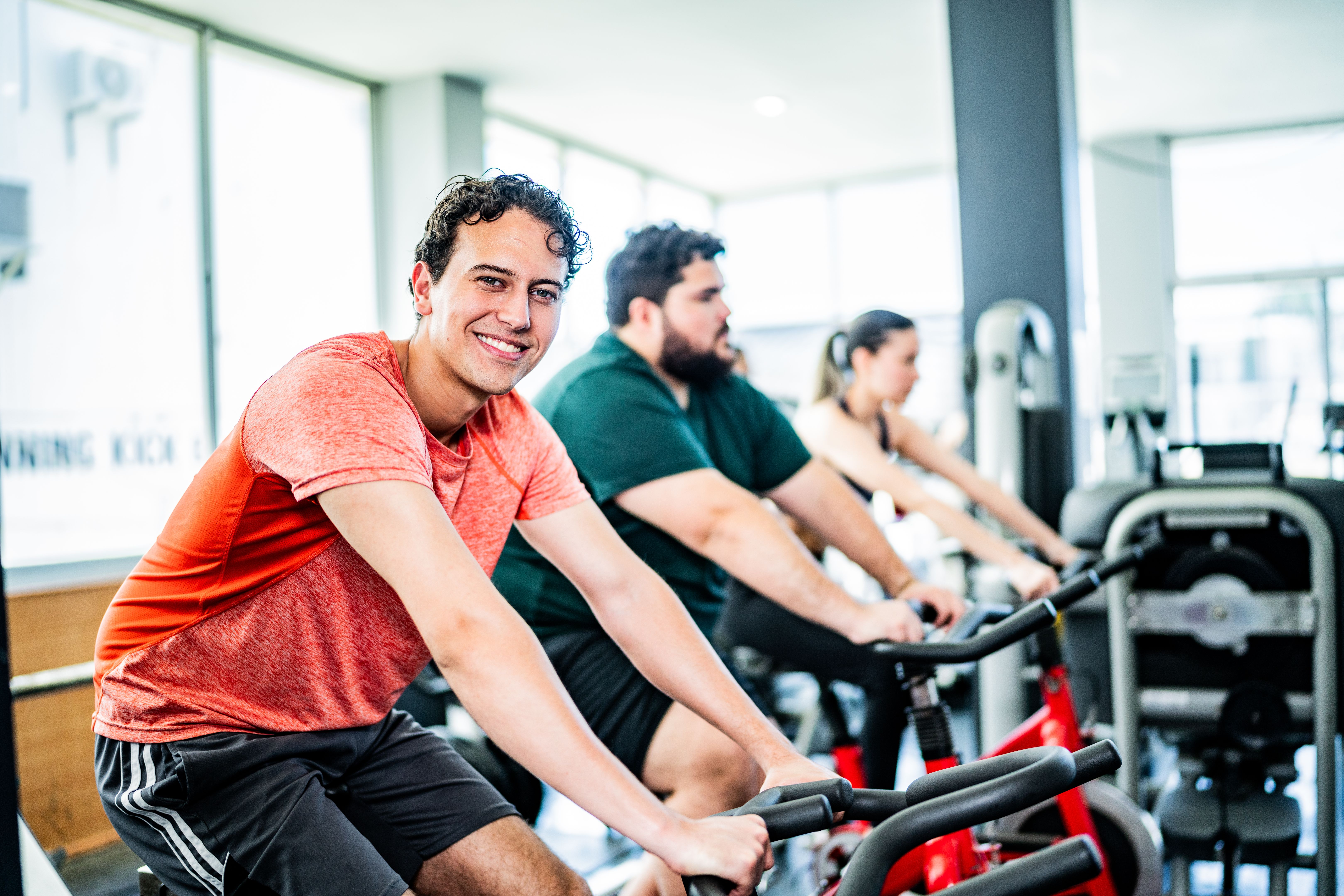 Portrait of young man on exercise bike at gym Portrait of young man on exercise bike at gym