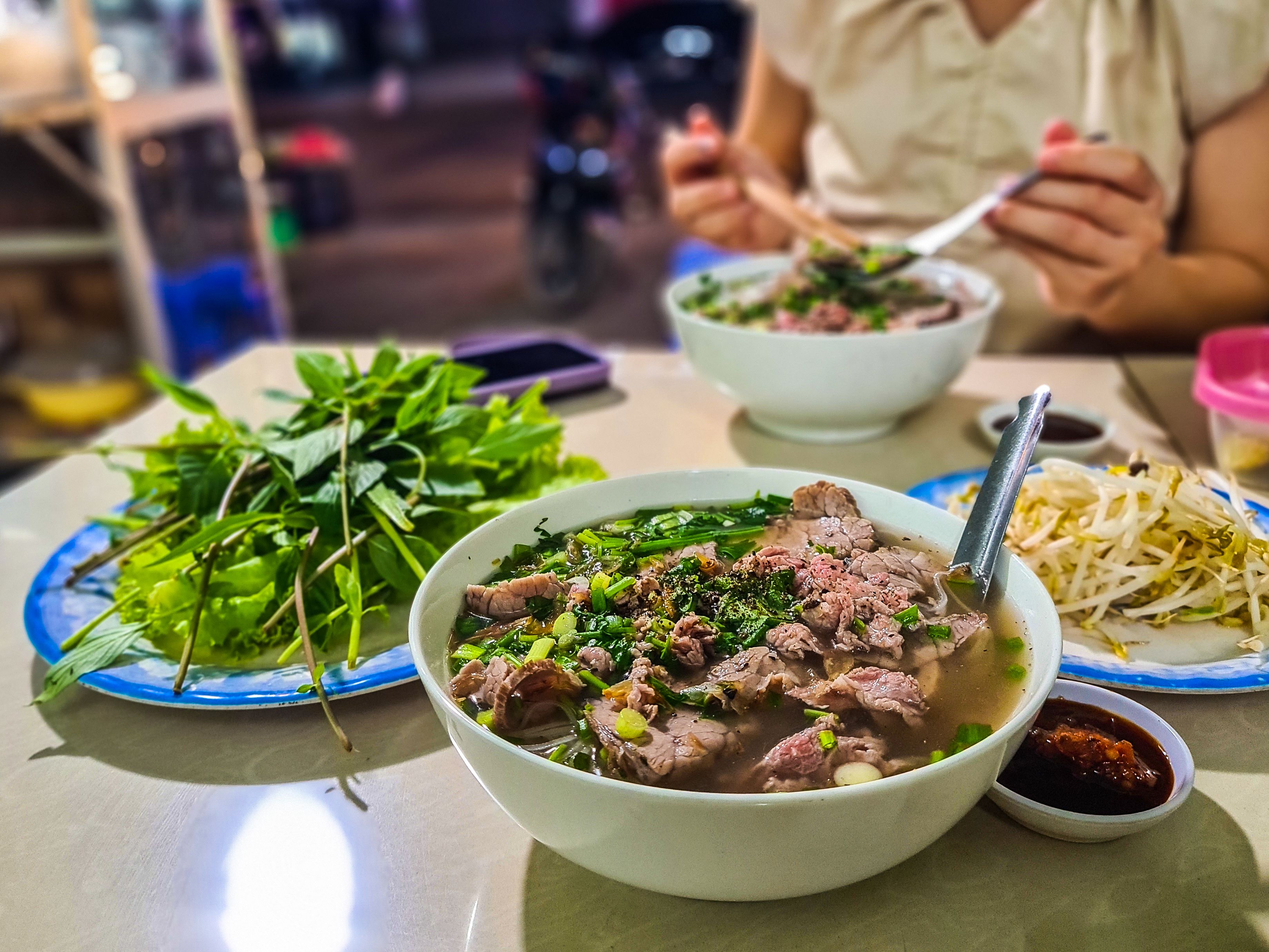 High-Quality Image of Vietnamese Beef Noodle Soup (Phở Bò) – Hearty Bowl with Fresh Herbs and Condiments
