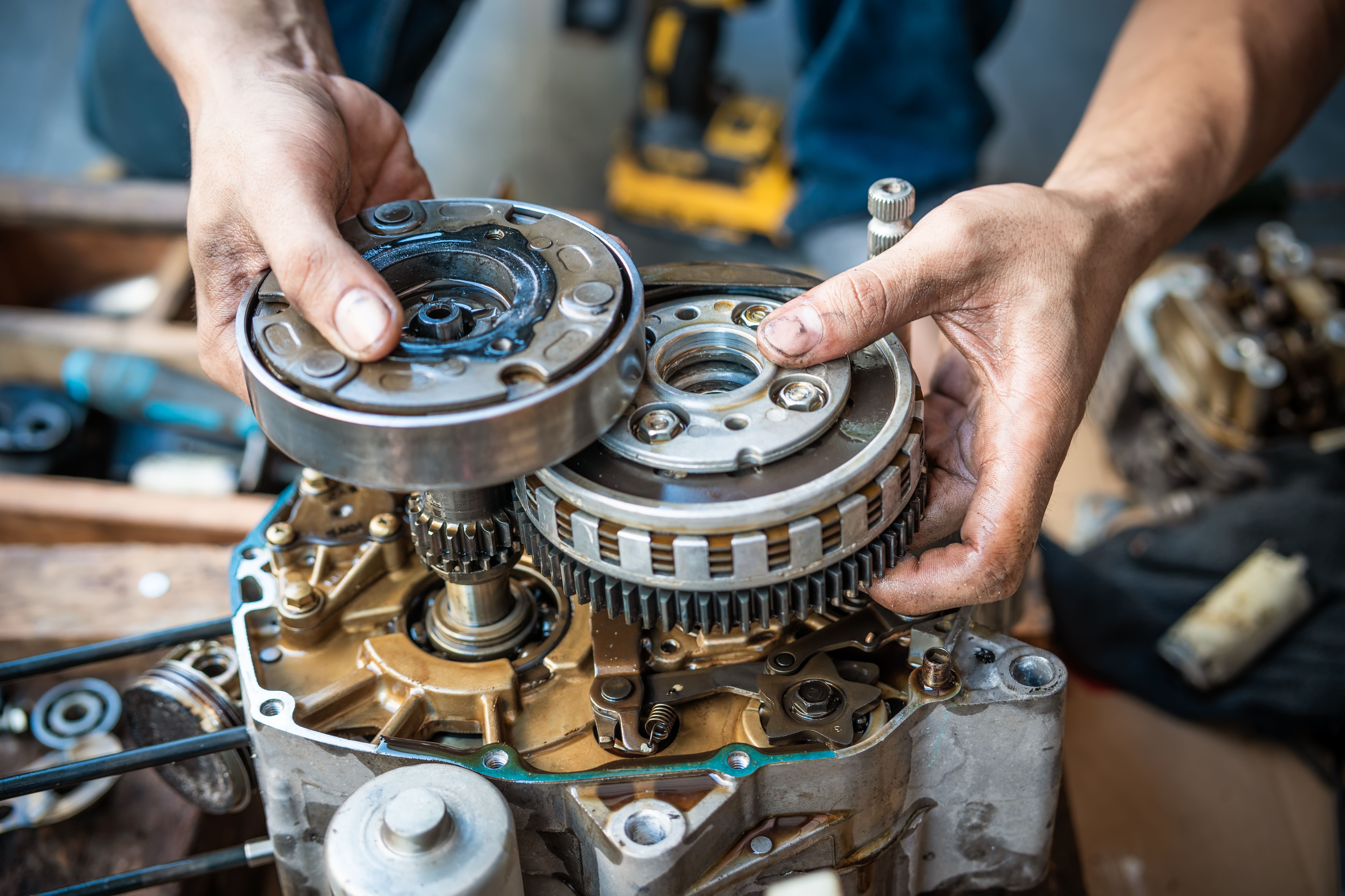 Motorcycle mechanic working on the repair of a motorcycle engine ,working at garage, maintenance, repair motorcycle concept