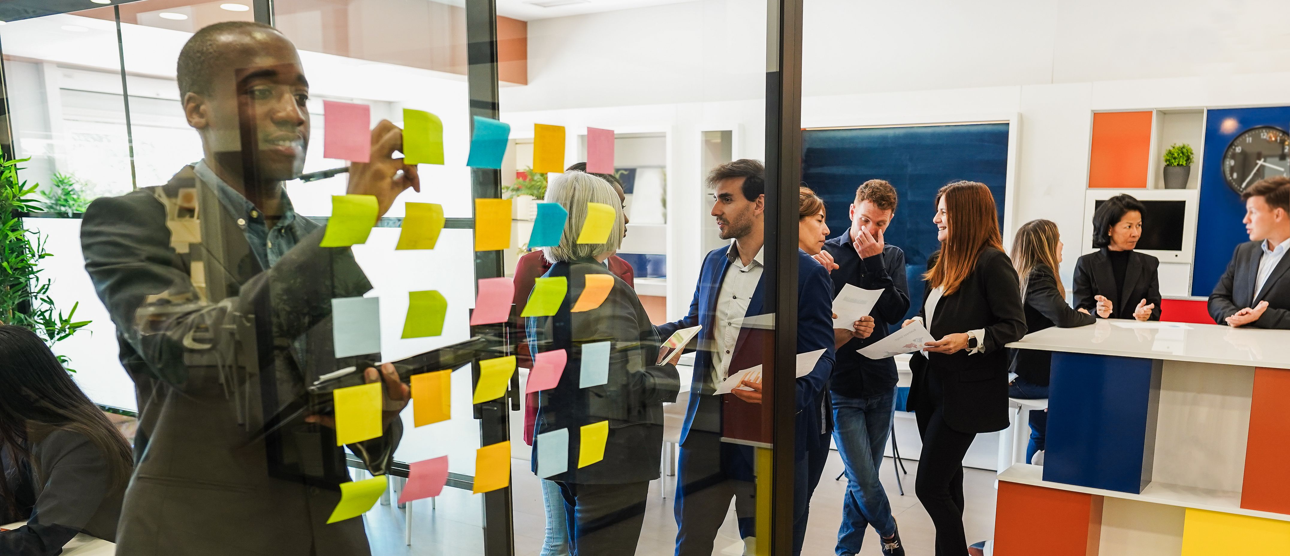 Multiracial colleagues working inside business office with glass walls - Entrepreneurs people sharing ideas at teamwork meeting - Brainstorming and startup concept - Main focus on center hispanic man