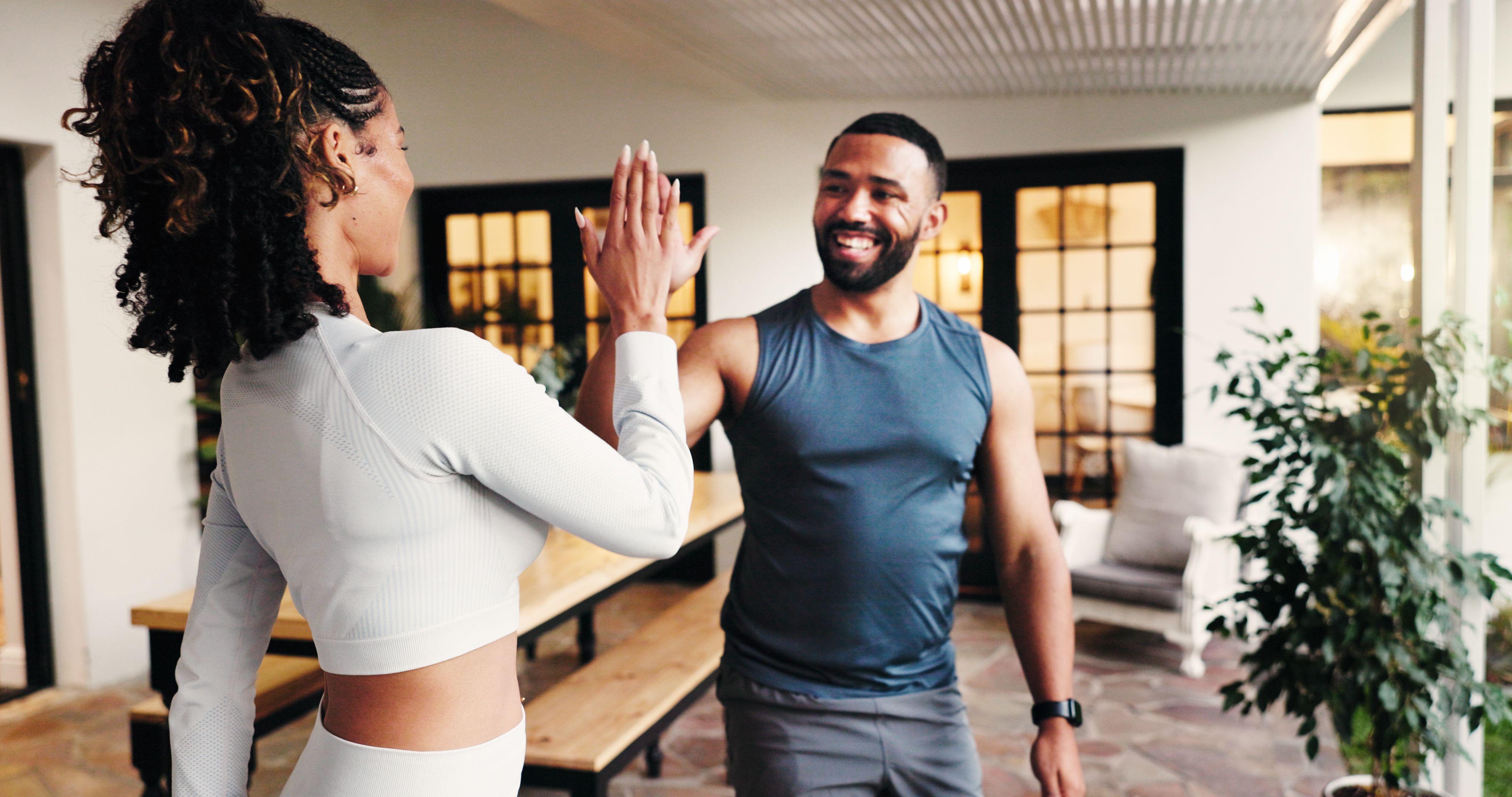 Couple, happy and exercise in home, high five or support with smile for training, motivation and workout. People, man and woman with celebration for fitness, success and cheers for goals at apartment