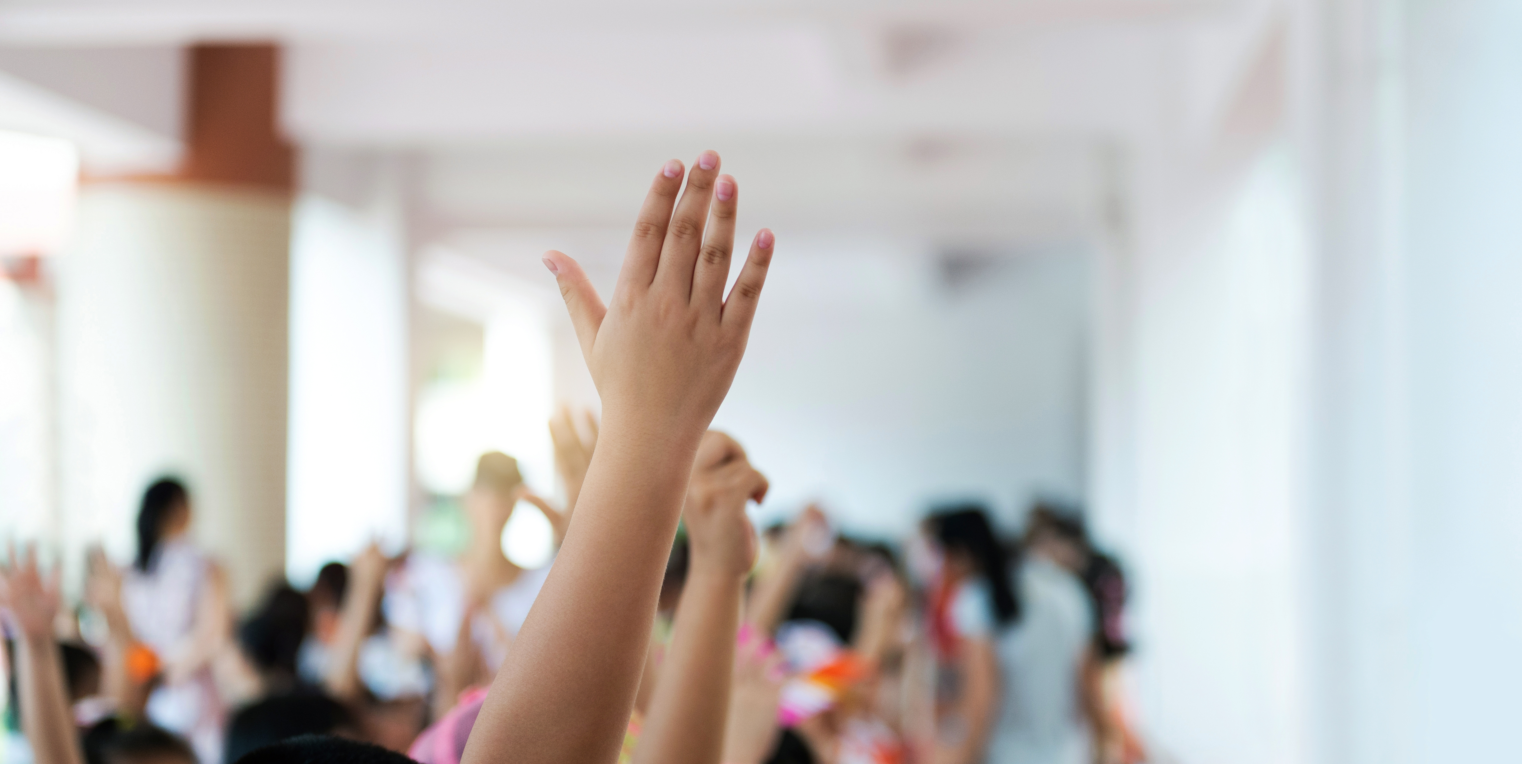 Group of happy children with their hands up
