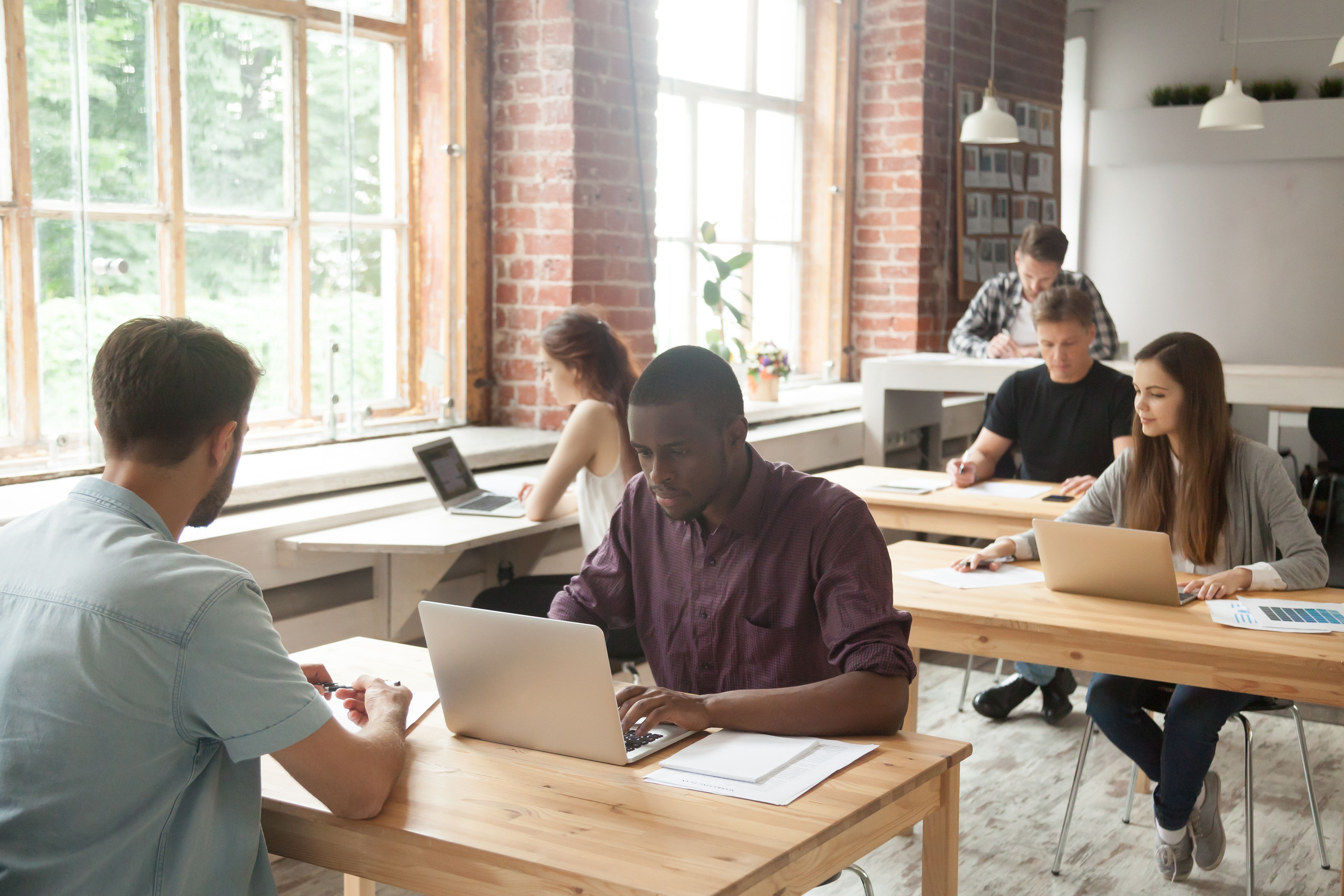 Équipe multiethnique de collègues au travail dans les bureaux partagés.