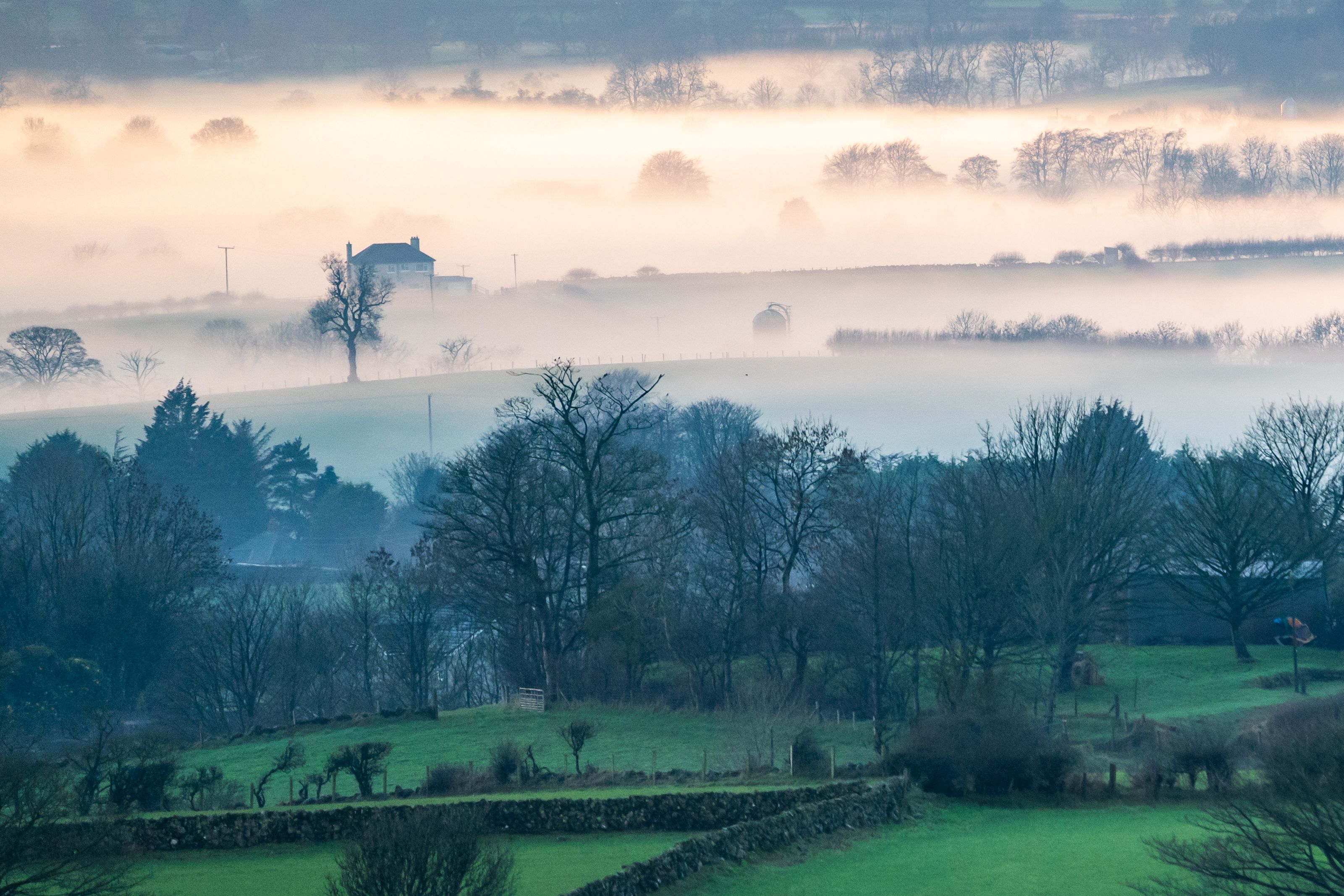 Mist forming over countryside in Northern Ireland on a winter evening