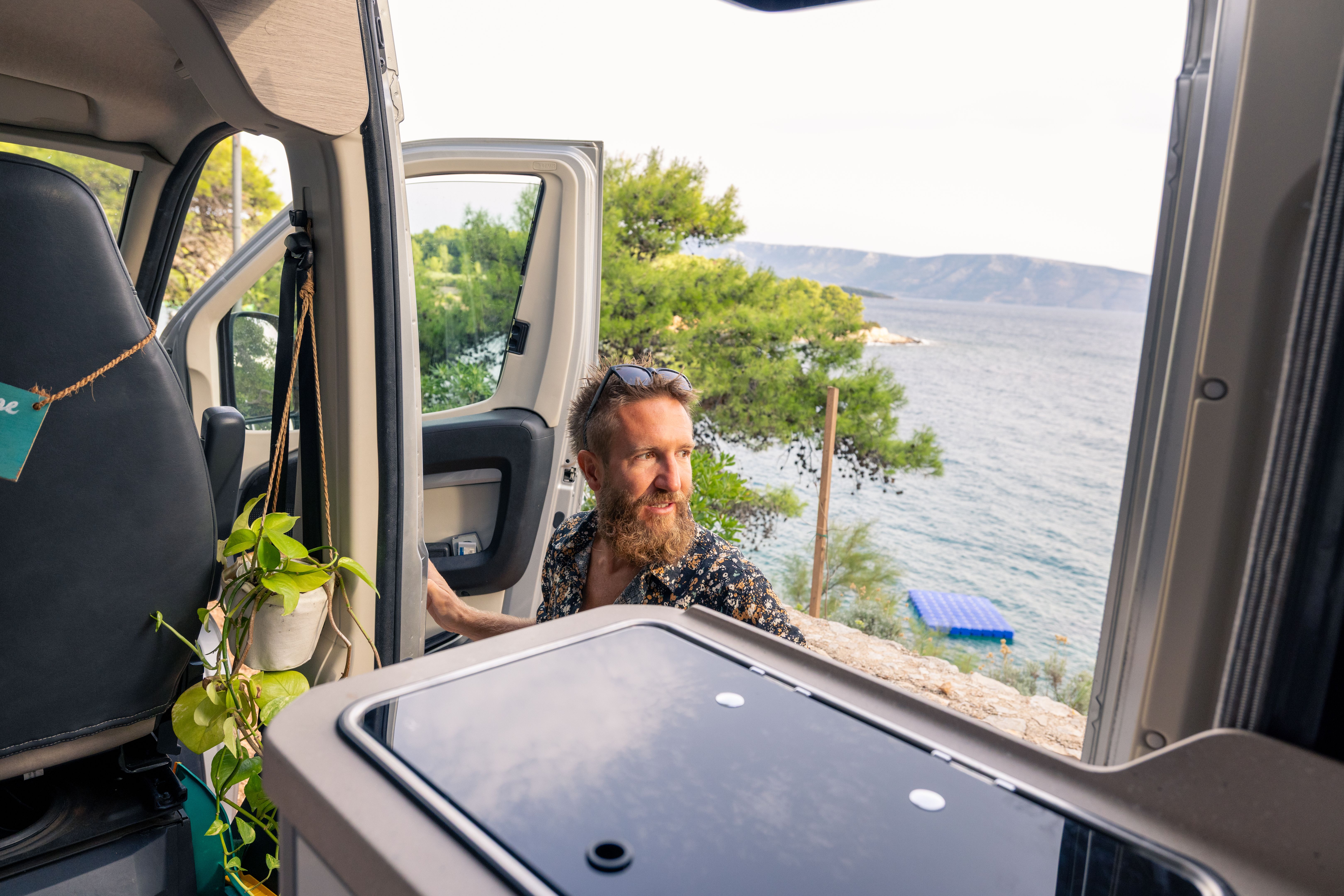 Man Enjoying Coastal View from Camper Van Door
