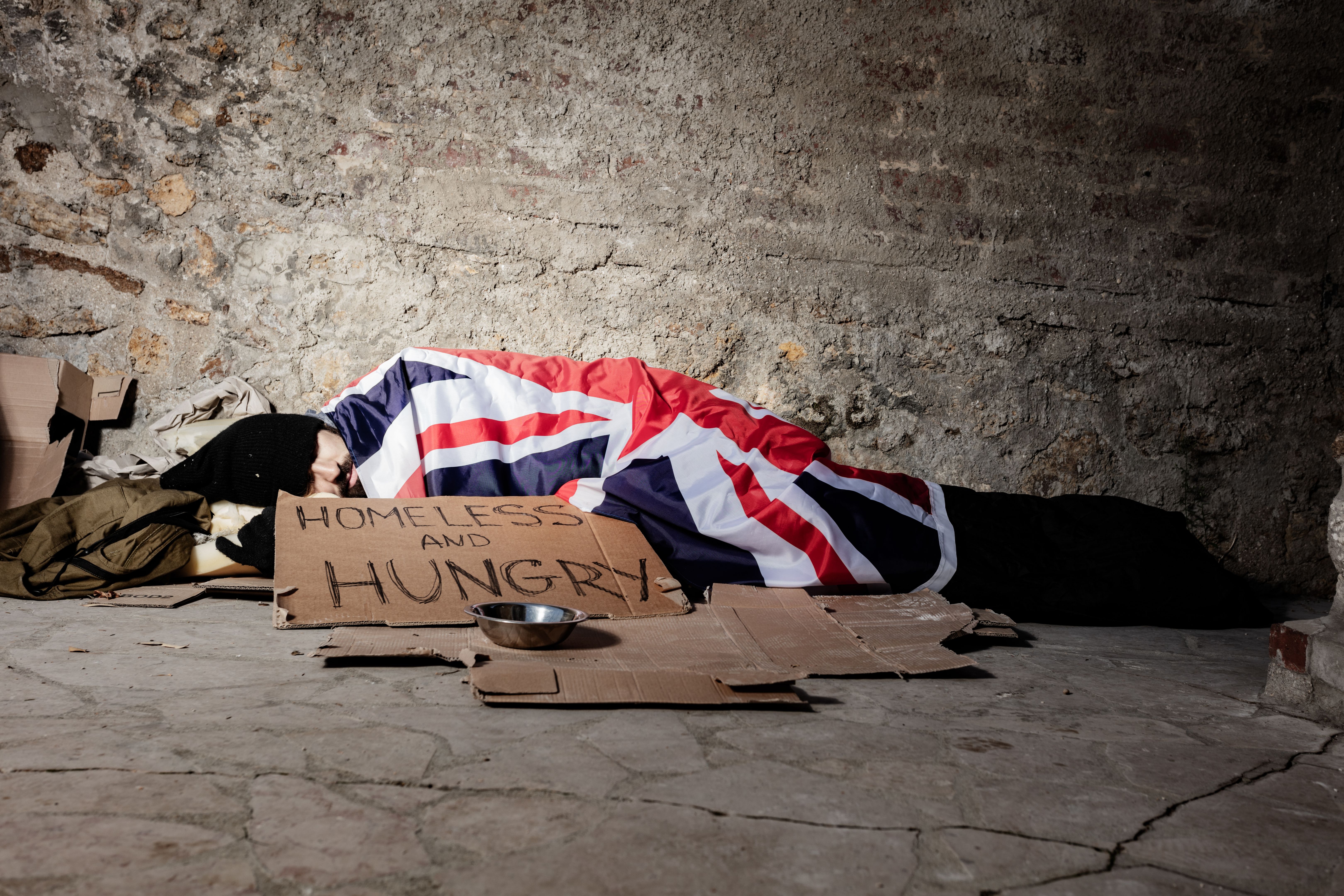 Man sleeping on street under Great Britain flag