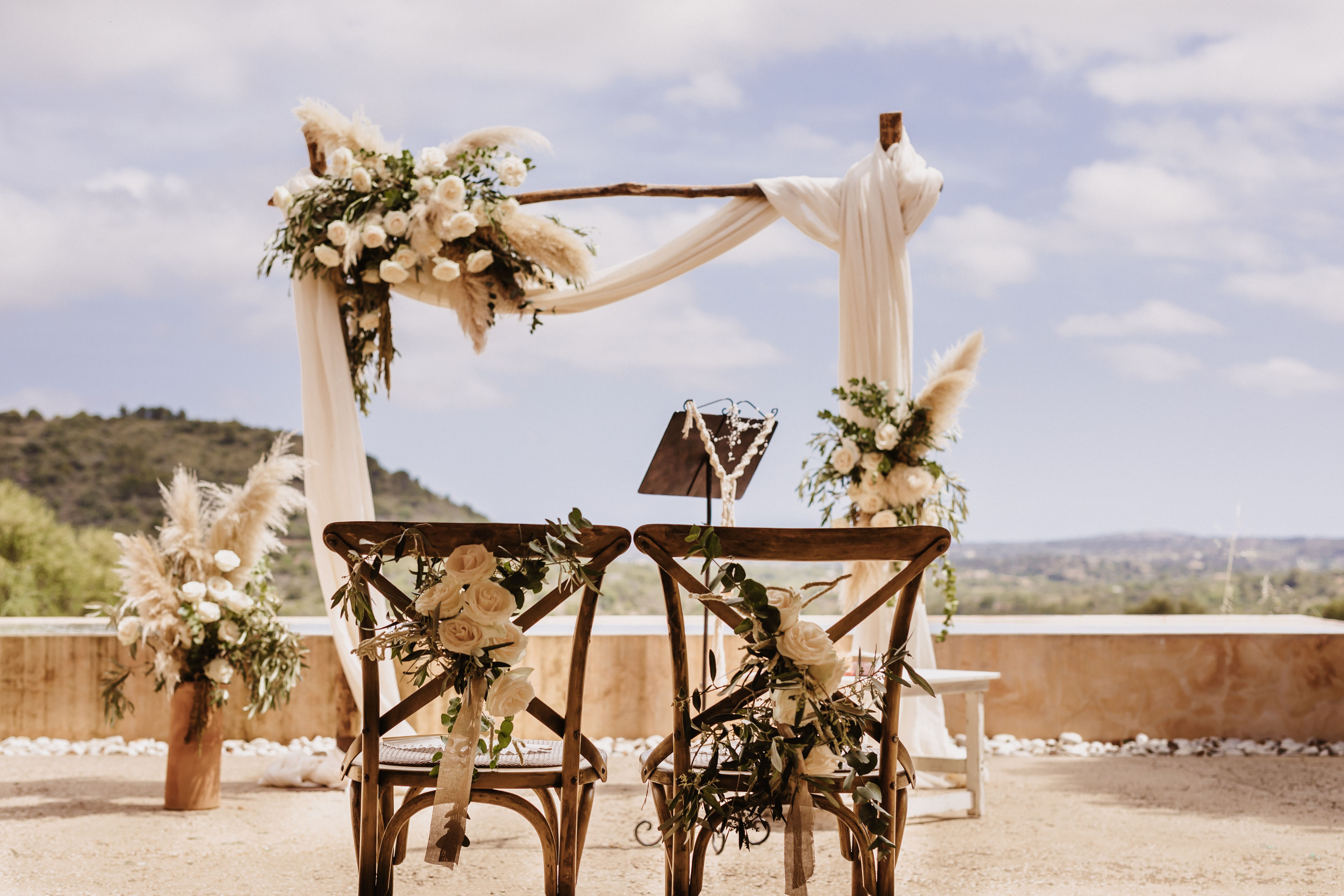 Boho wedding altar with two wedding chairs and boho flowers