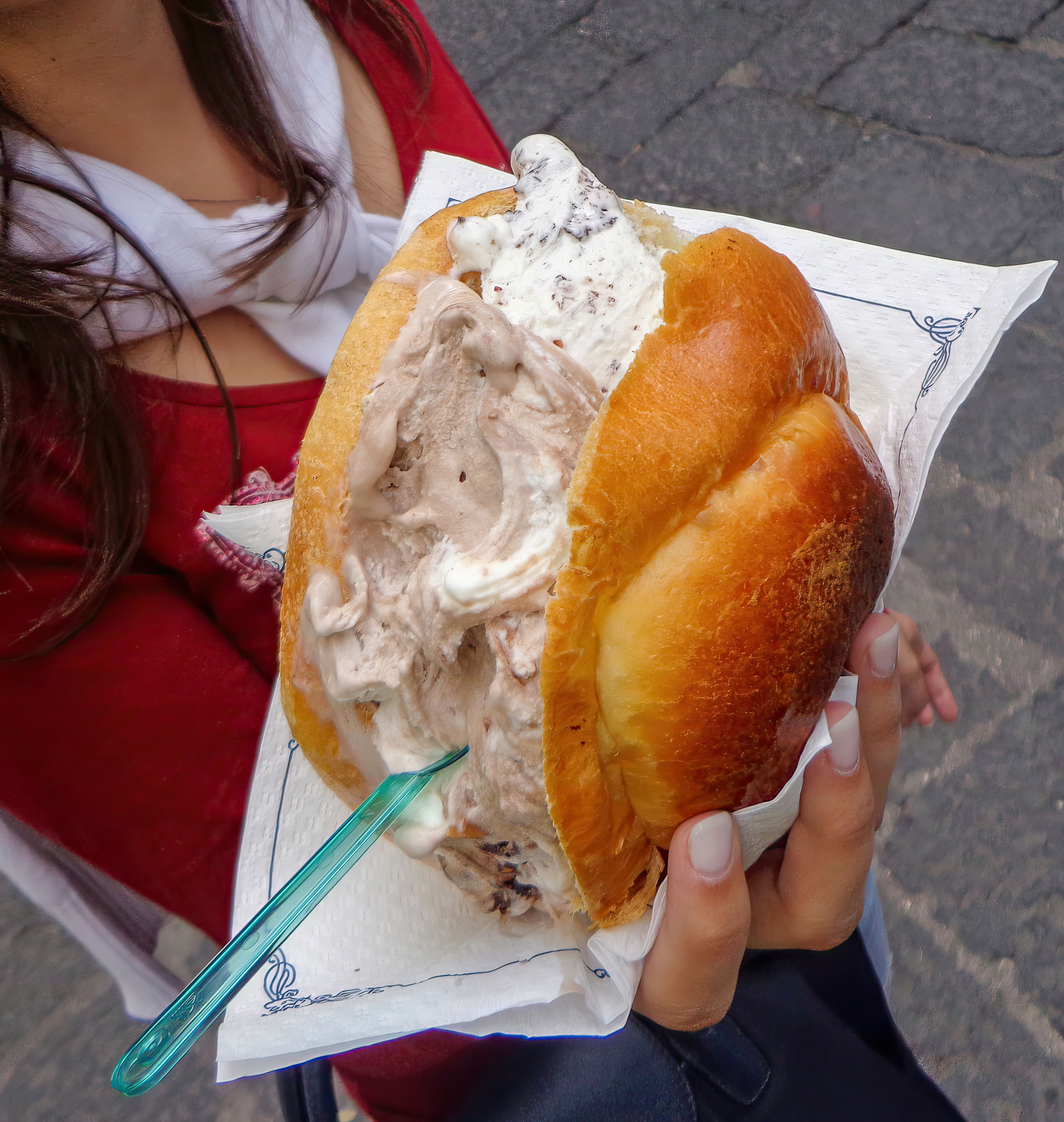 Woman holding a delicious brioche con gelato in italy