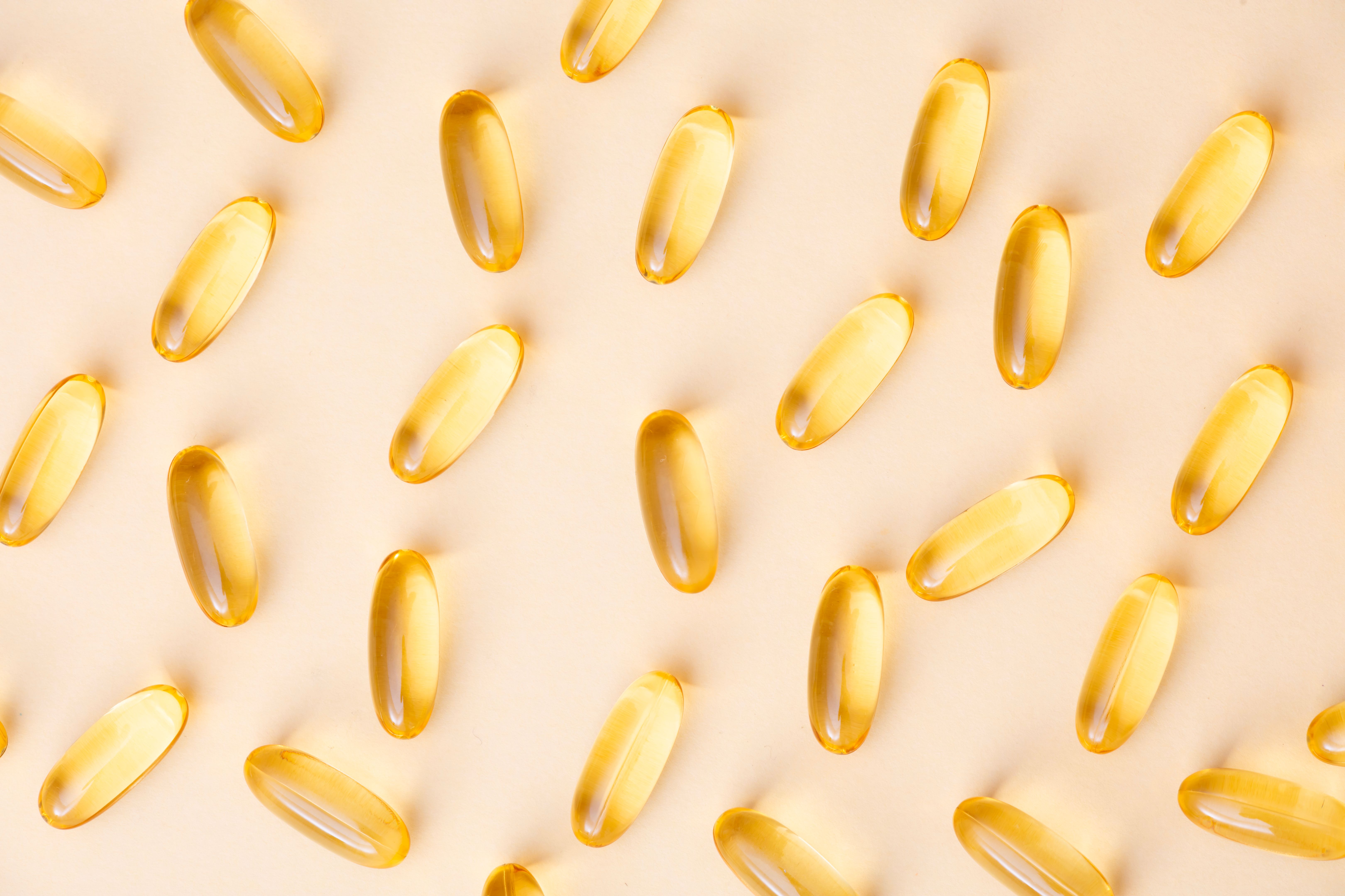 Yellow Softgel Capsules on Beige Background
