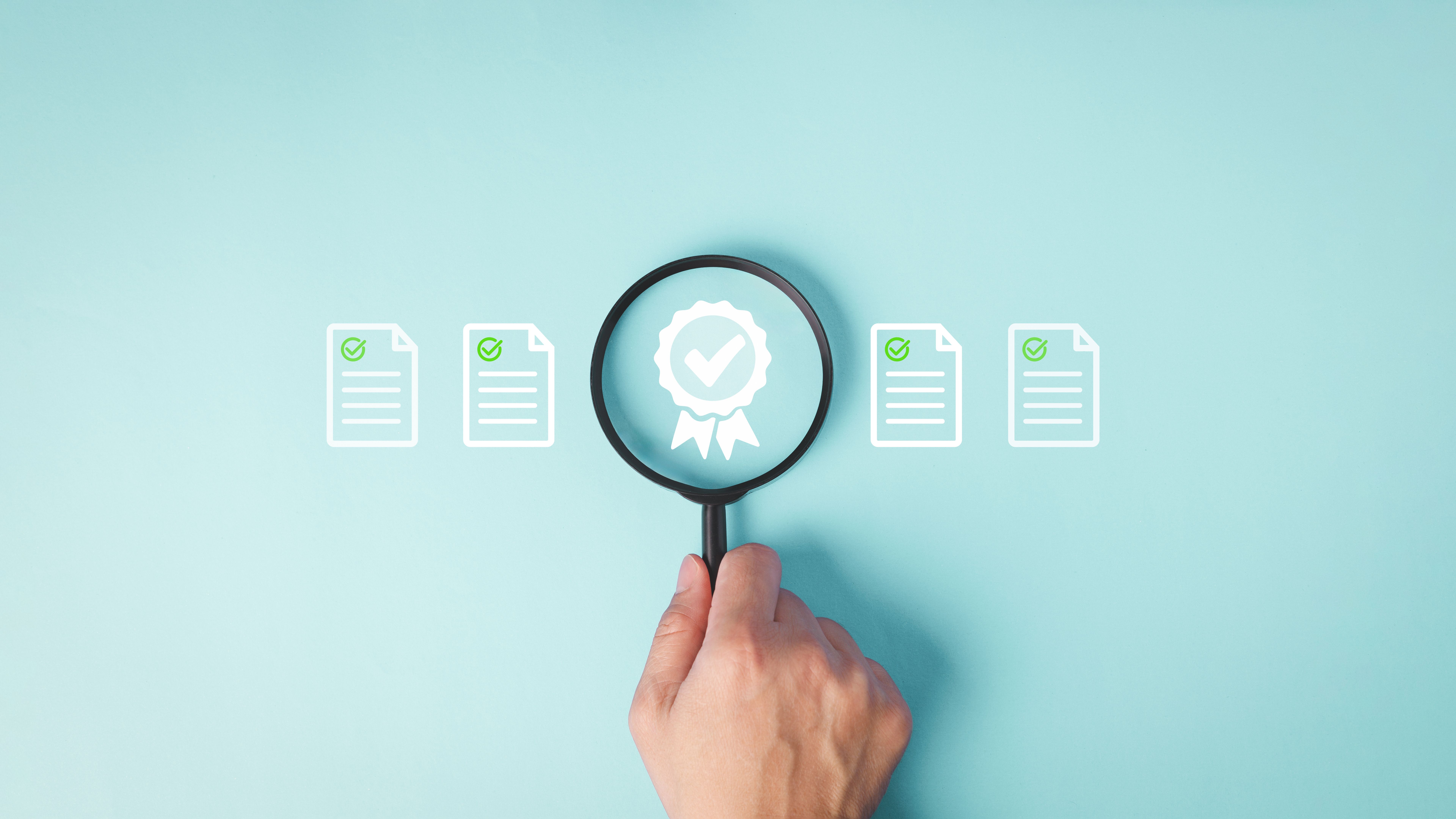 Hand Holding Magnifying Glass Over Quality Assurance Certificate. Hand Holding Magnifying Glass Over Quality Assurance Certificate.