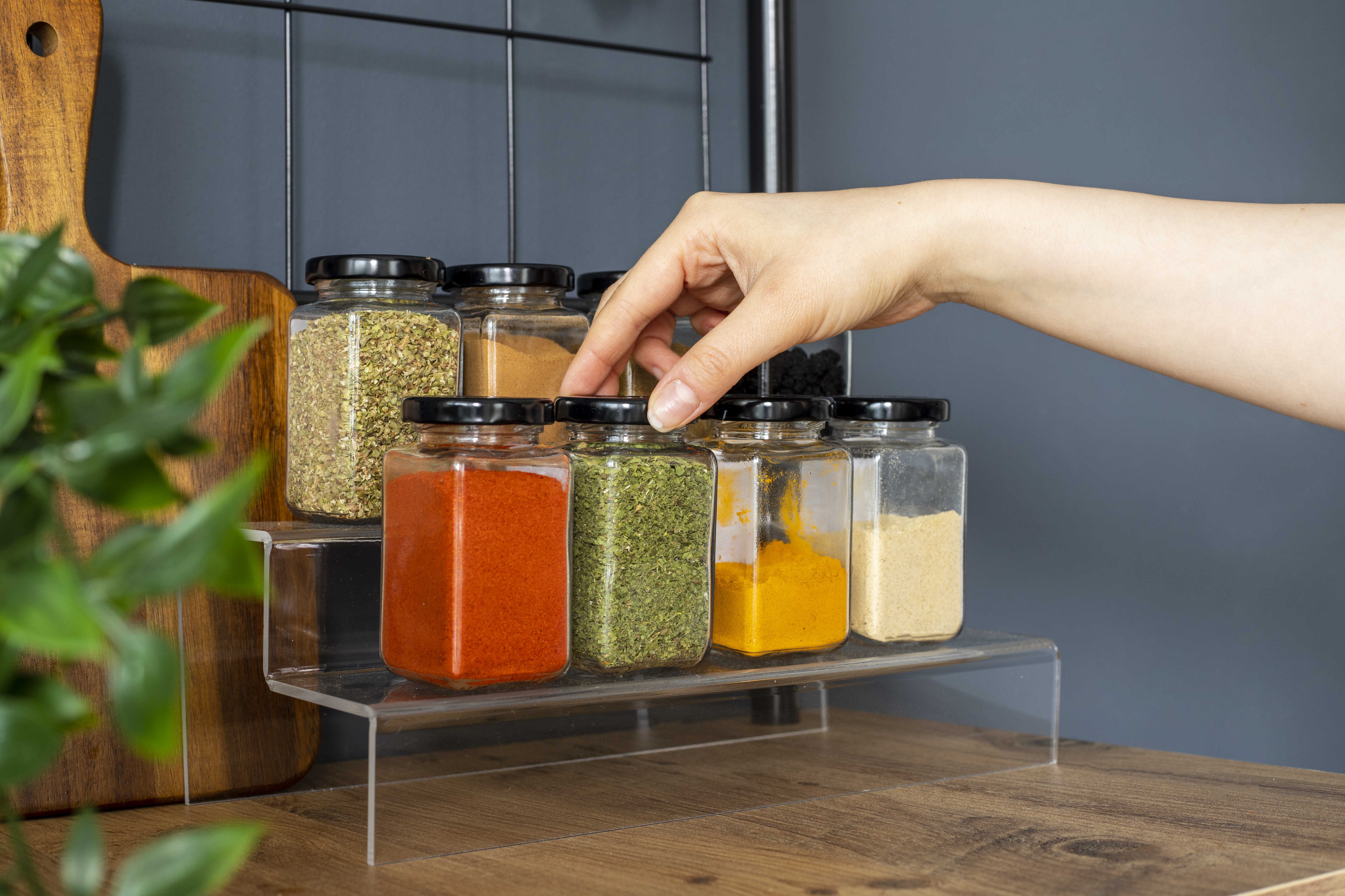Cropped hand holding jar of spices on kitchen. Cropped hand holding jar of spices on kitchen.