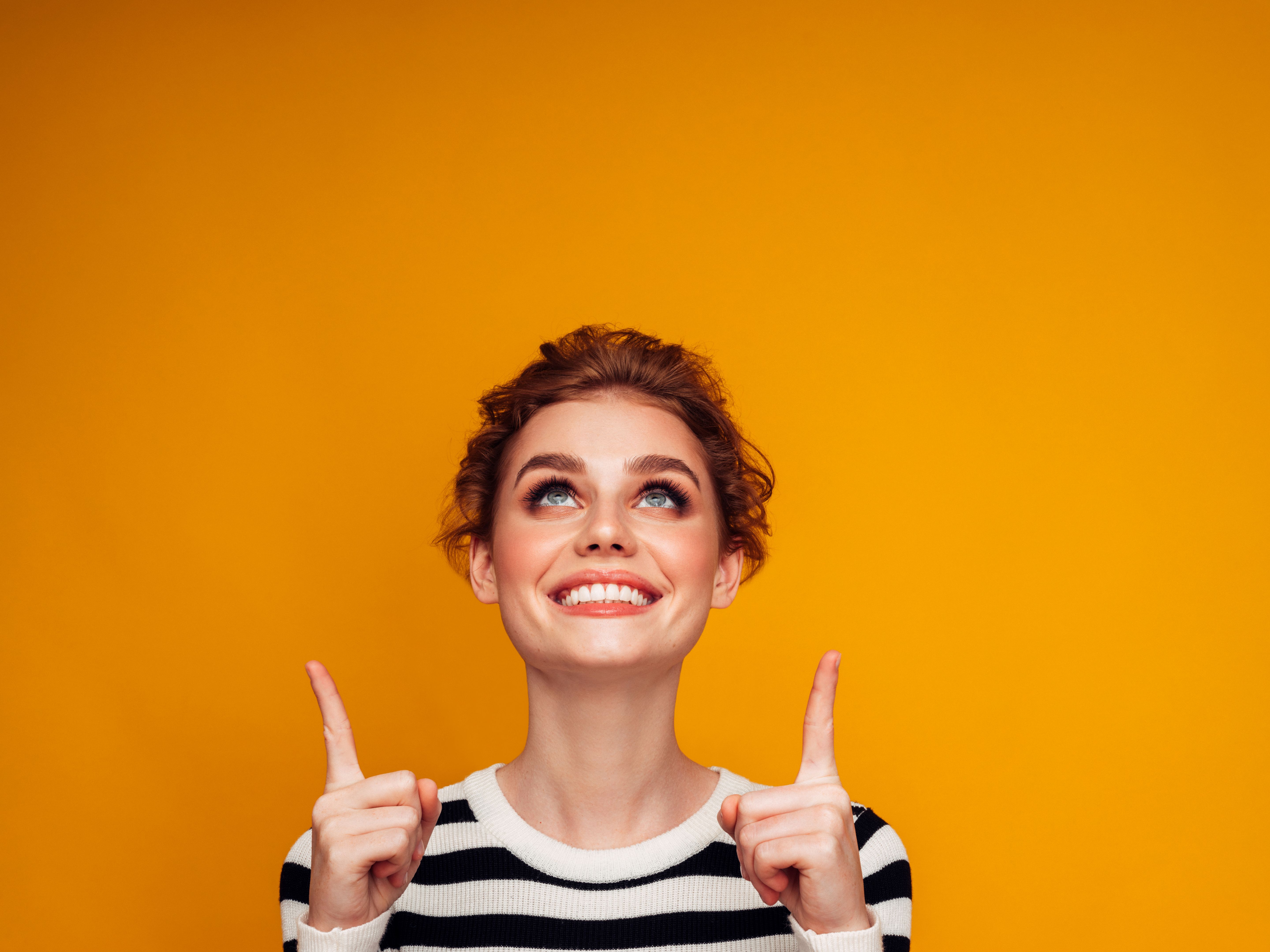 Beautiful woman pointing up